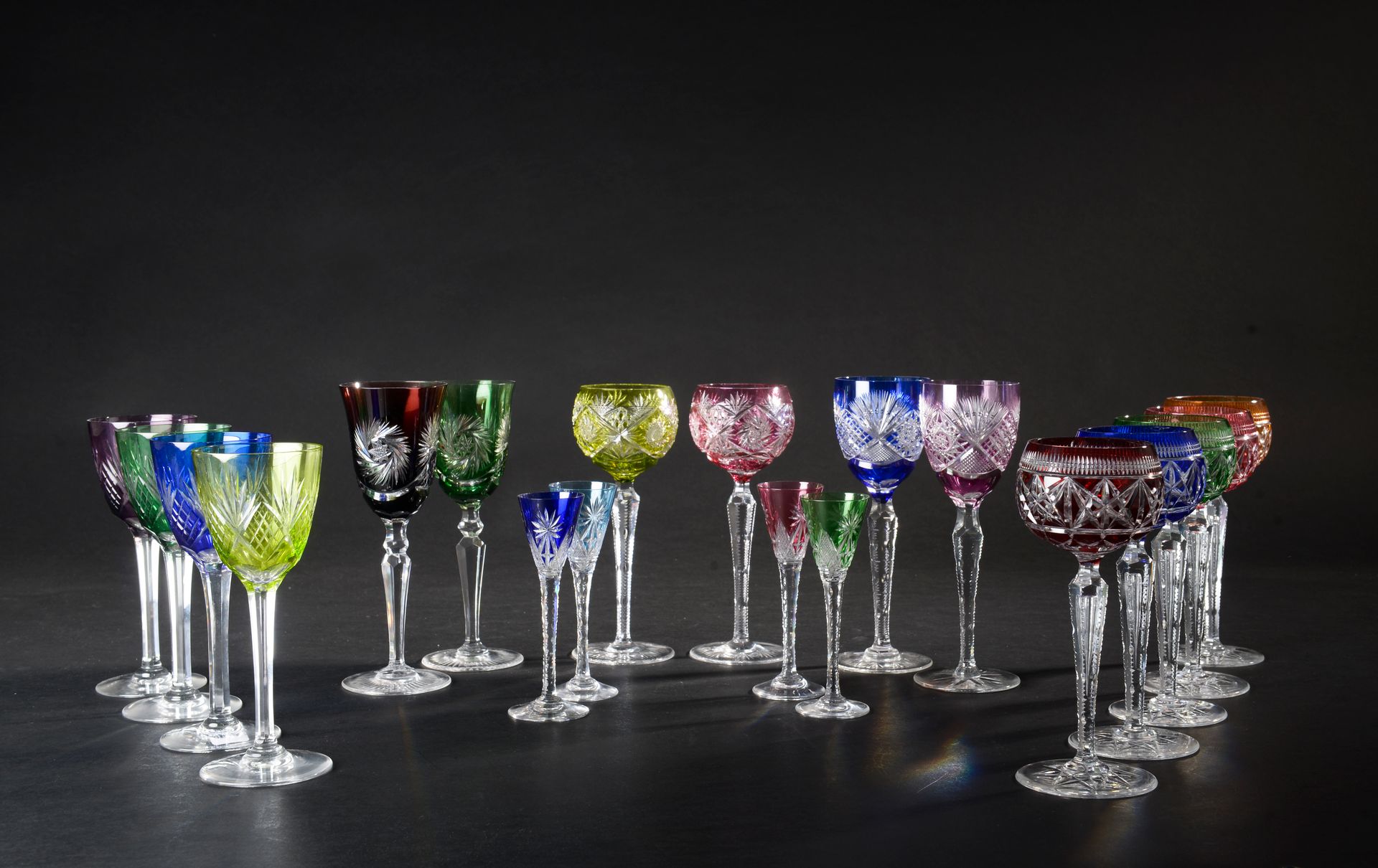 Null 一套15个不同型号的切割彩色叠层水晶杯。
高度：19至21厘米。从19至21厘米
四个较小的玻璃杯，也是彩色套色水晶。
高度：15厘米。高度：15厘米