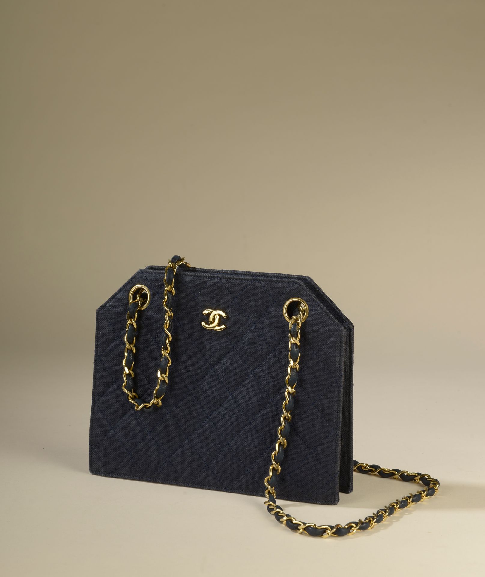 CHANEL. Navy blue quilted canvas bag, a gold metal chai…