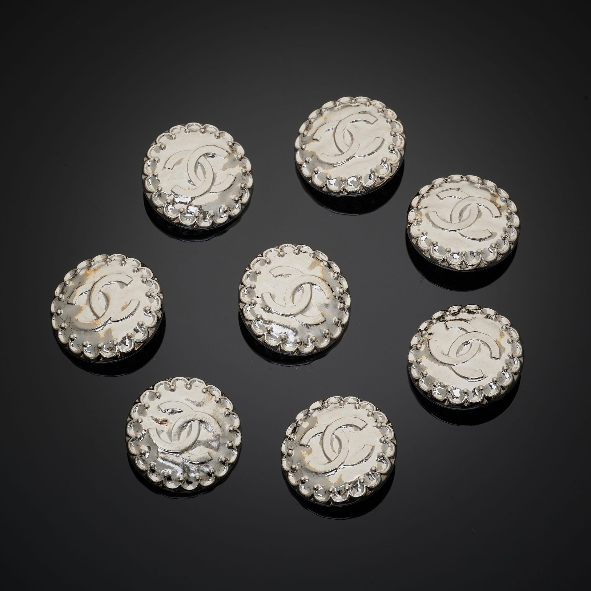 CHANEL. Set of eight silver metal buttons with double …