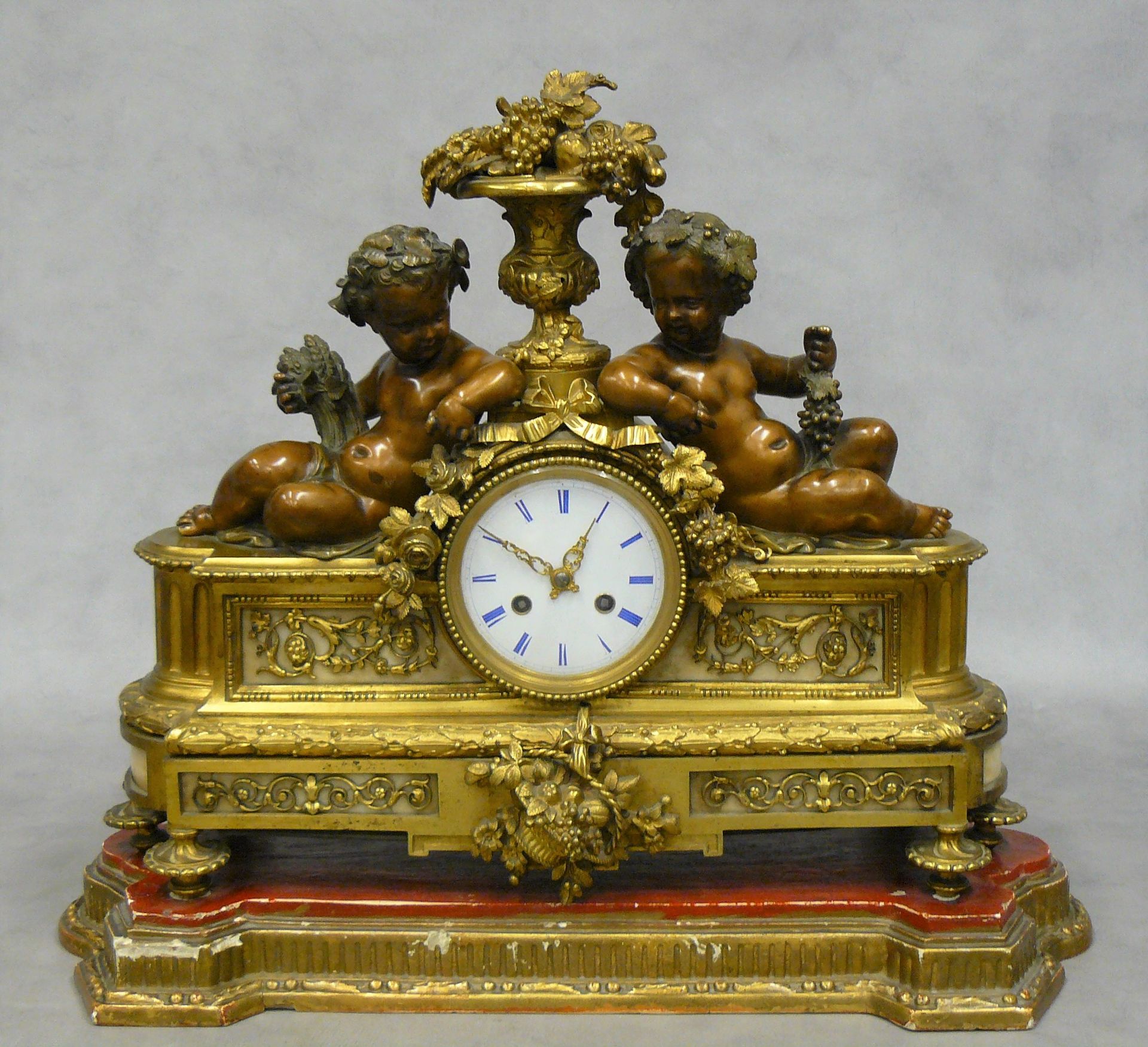 Null Clock with loves framing a Medici vase decorated with fruits and foliage, i&hellip;