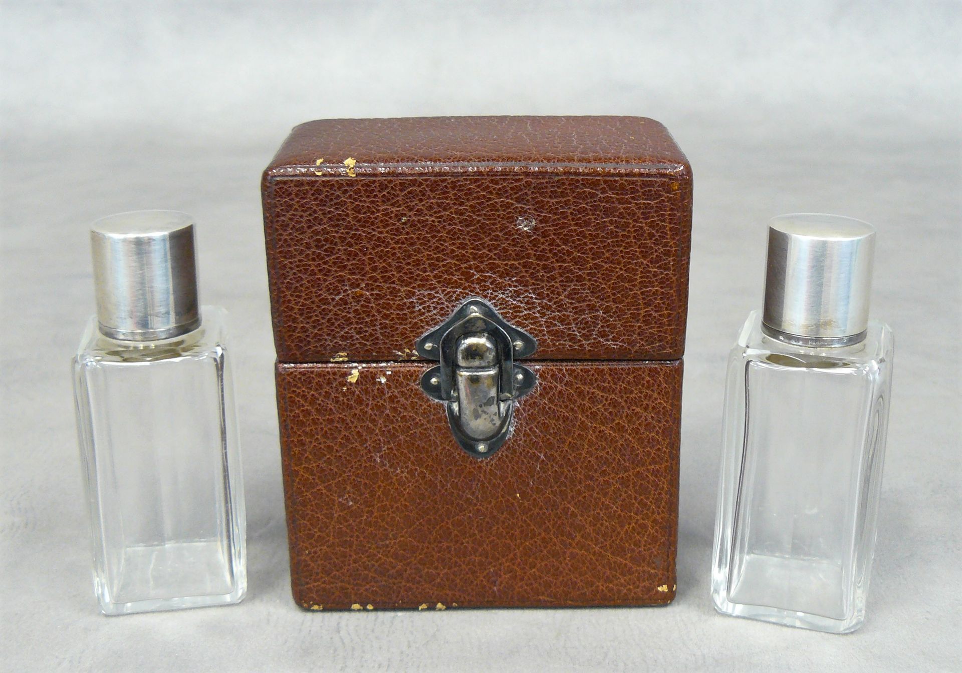 HERMES 
巴黎爱马仕：一个有签名的皮箱，里面有两个玻璃香水瓶，银质框架上有签名 - 11 x 9,5 x 5,5 cm