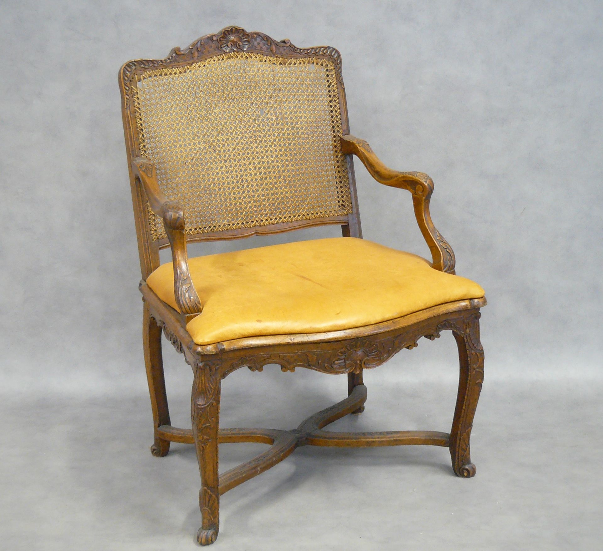 Null 摄政时期的扶手椅，藤条底座，用天然木材雕刻贝壳和叶子，弯曲的腿由一个支架连接；一个皮套装饰的座位 - 96 x 66.5 x 61厘米