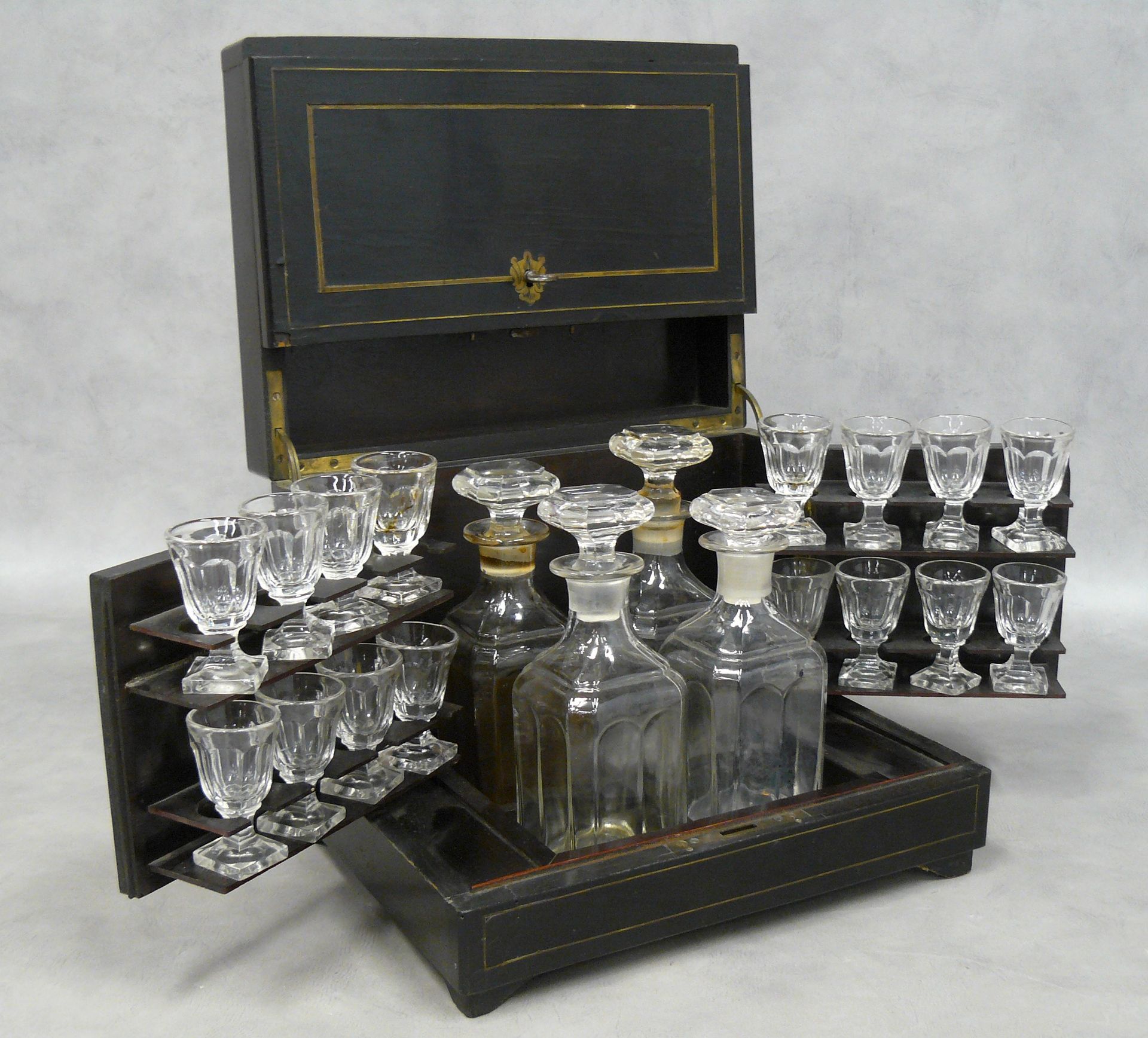 Null 一个拿破仑三世的酒柜，用发黑的梨木和黄铜杆（缺失和损坏），配有四个醒酒器和十六个杯子，有腿。
