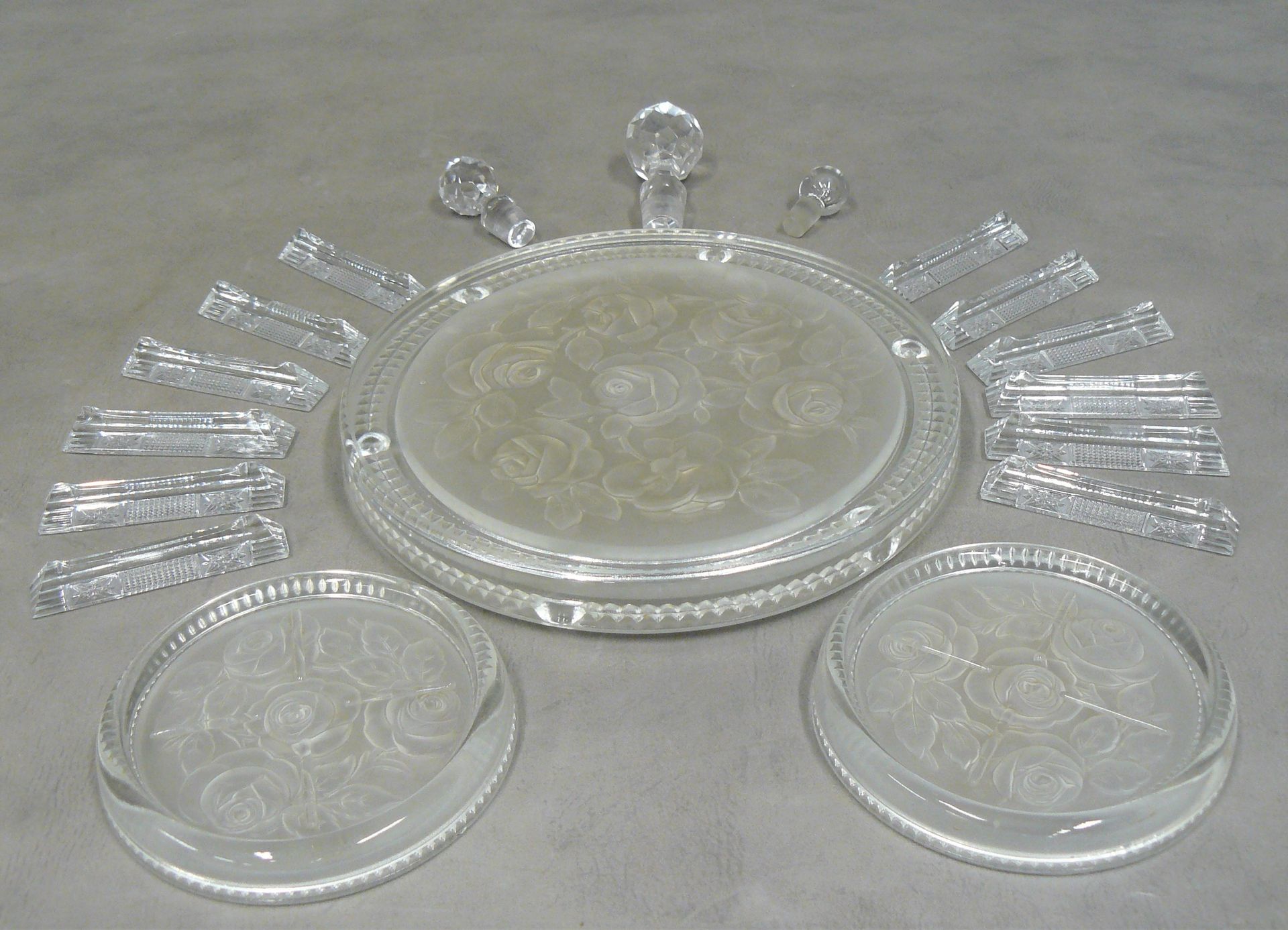 Null 一个杯垫--直径23厘米，两个带玫瑰装饰的乳白色玻璃杯垫，12个带星形图案的玻璃刀架；附三个咖啡壶塞子