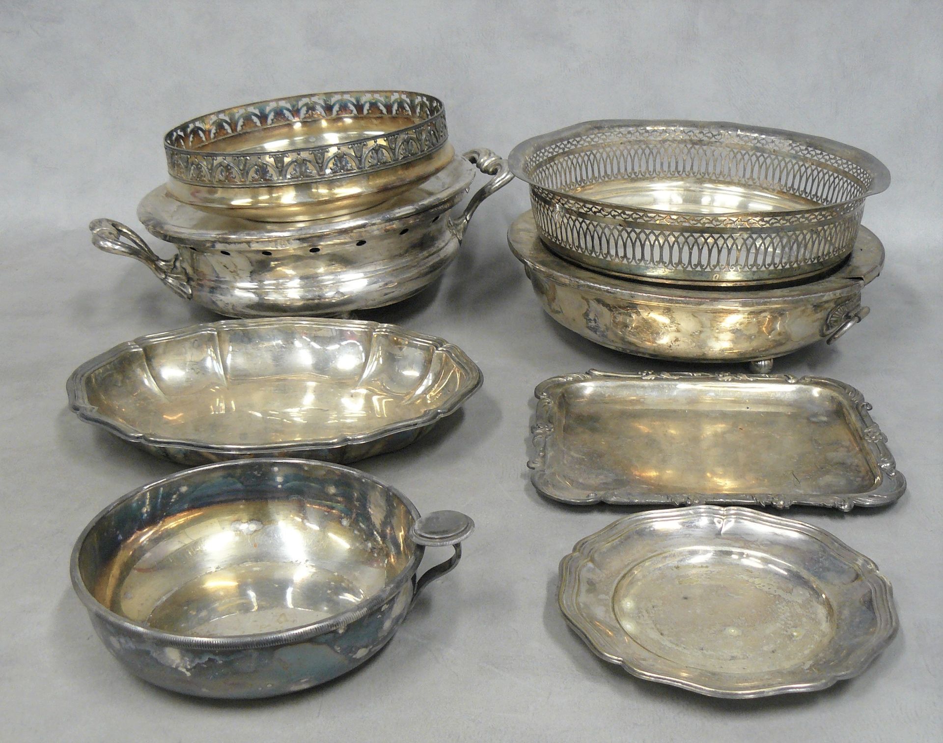 Null 一套金属器皿：两个暖盘，其中一个已损坏，一个小托盘，两个篮子，一个酒杯，一个杯垫和一个装饰性的品酒器