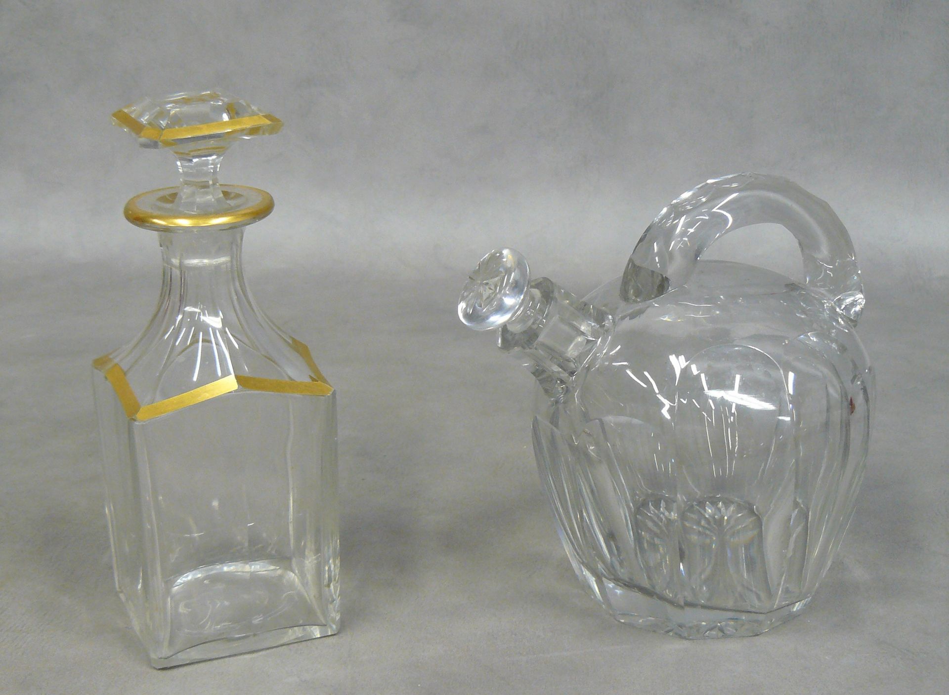 Null a square decanter with a golden stopper and a watering can decanter