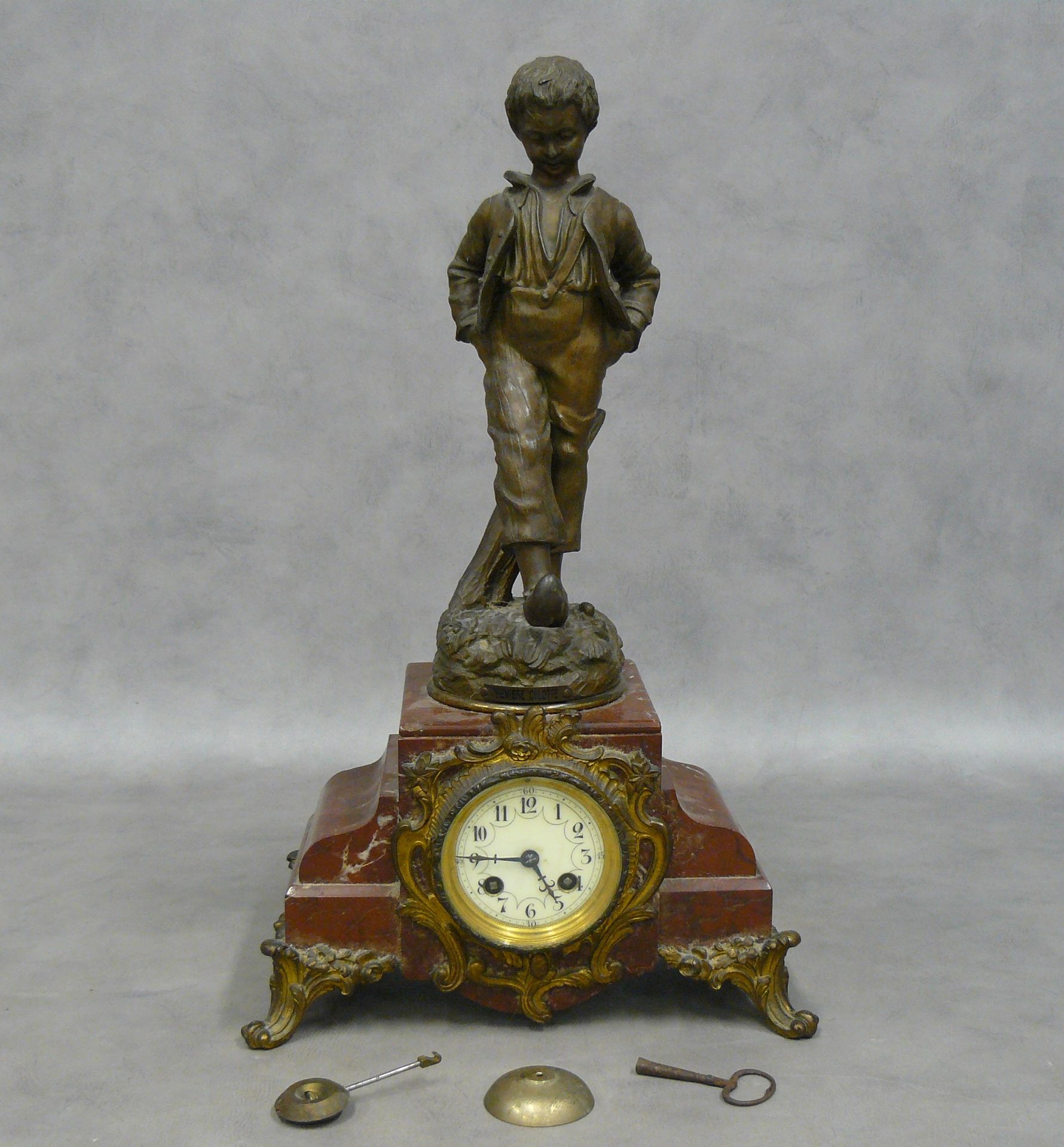 Null eine Uhr aus Griotte-Marmor, gekrönt von einer Statuette in Regula, genannt&hellip;