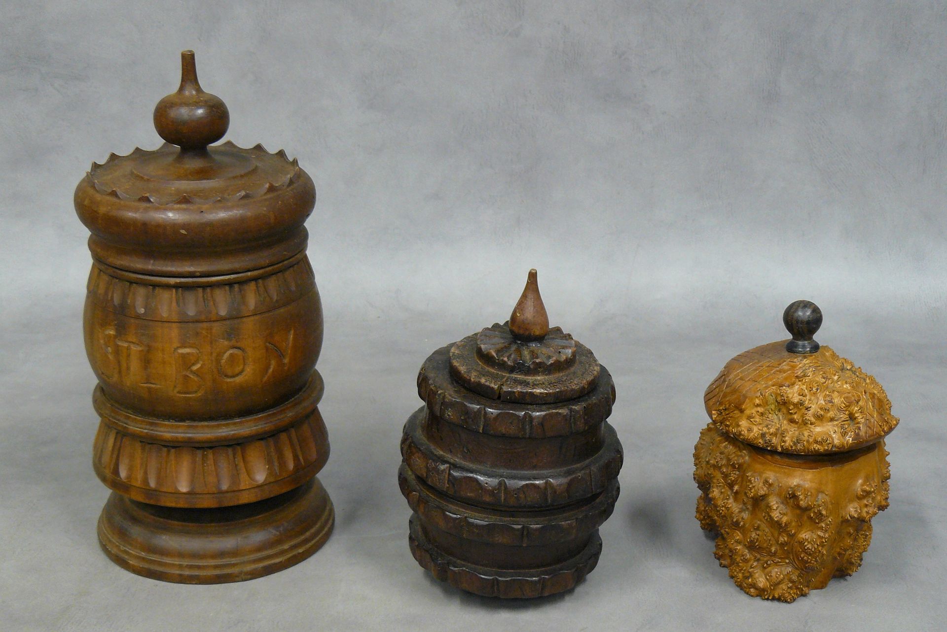 Null un set di tre vasi da tabacco in legno, uno marcato St Bon - 16,5 a 29,5 cm