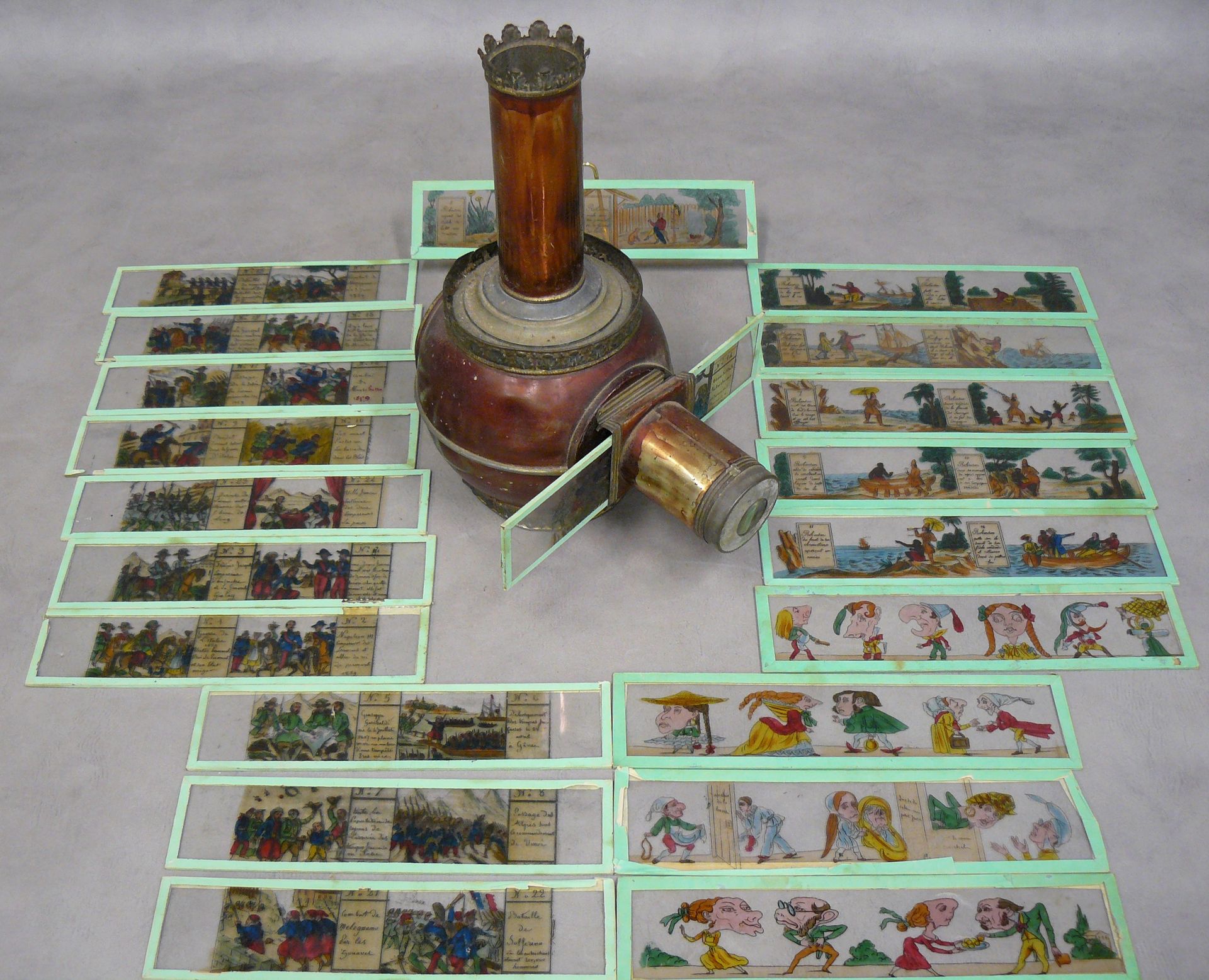 Null 一个铜制的魔术灯笼--27 x 23厘米，有两个彩绘玻璃视图的盒子，其中包括：11个关于第二帝国的板块，6个关于罗宾逊的板块和4个各种漫画板块。