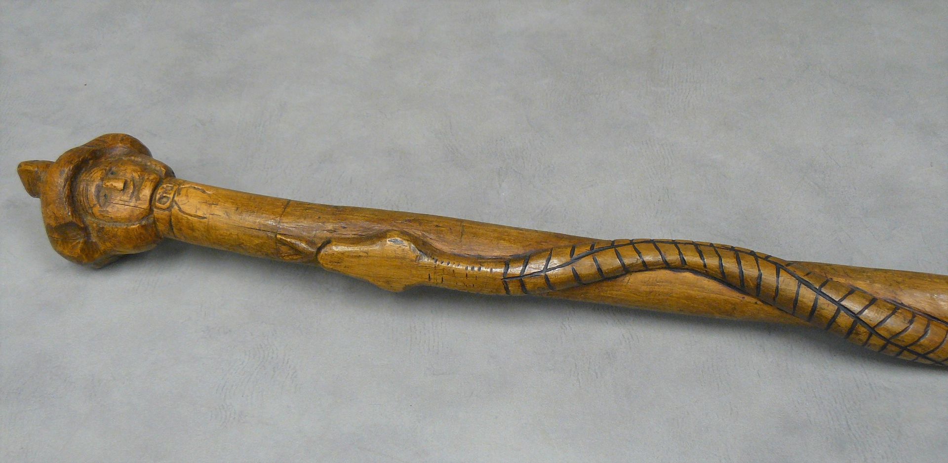 Null 长102厘米的木雕手杖，上面装饰着戴帽子的人头和一条蛇。