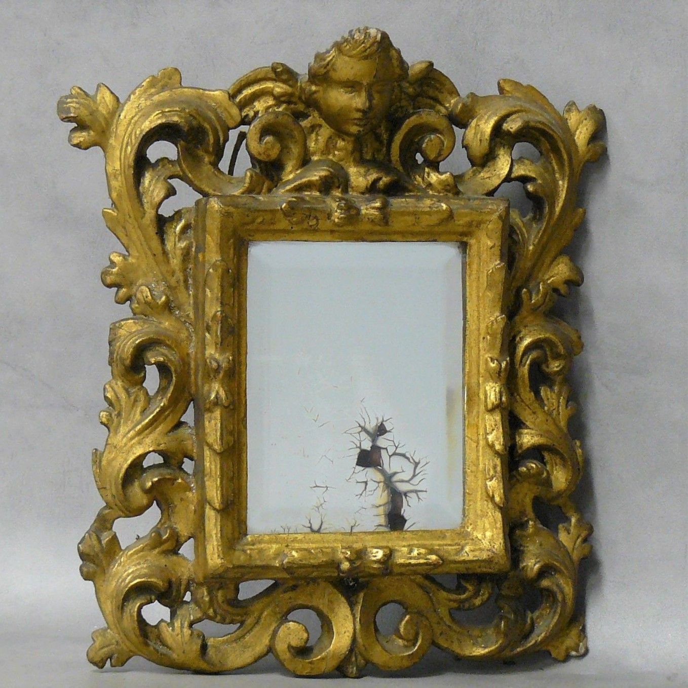 Null petit miroir en bois doré, ajouré et sculpté d'une tête d'angelot et de feu&hellip;