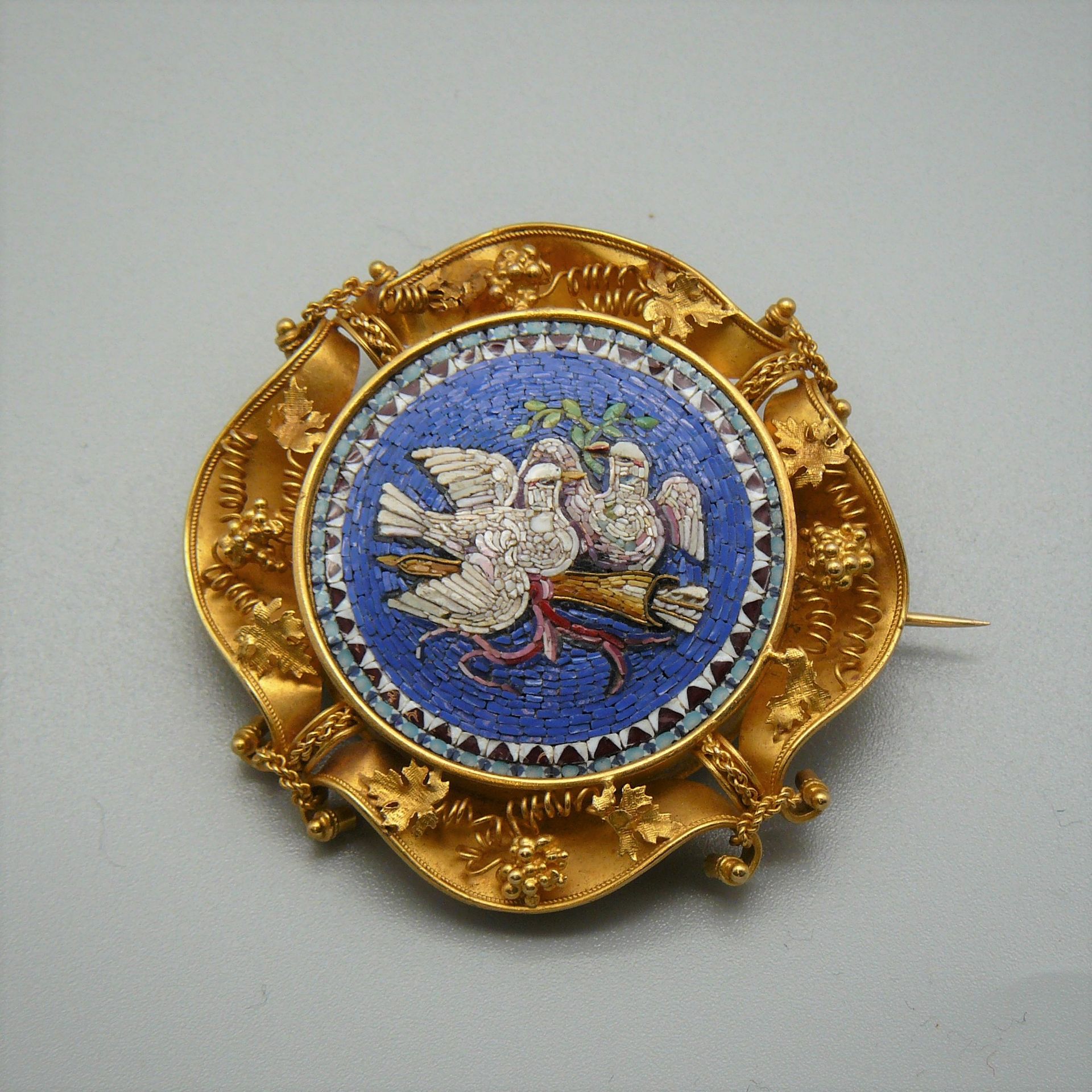 Null 一枚微型马赛克胸针，装饰有两只在箭筒上的鸽子，黄金环绕（百合花和猫头鹰标志），凿有藤叶，归于意大利佛罗伦萨。19世纪 - 总重18.65克
