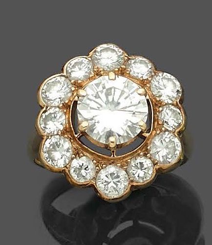 Null 黄金(750‰) "玛格丽特 "戒指，镶嵌13颗明亮式切割钻石，包括中间的一颗，重1.31克拉。
法国作品。
指头：48 - 毛重：6克
钻石附有宝石&hellip;