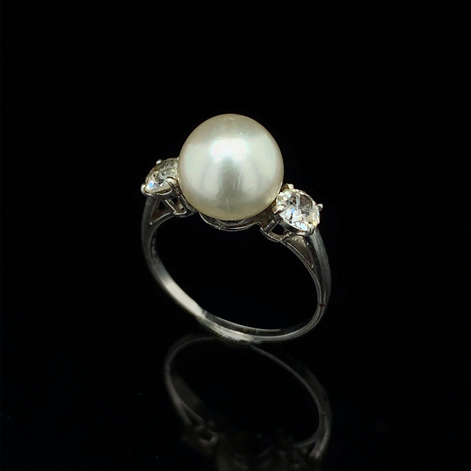 CHAUMET 铂金(950‰)和白金(750‰)戒指上镶嵌着一颗珍珠(未经测试)，白色，略带梨形和纽扣，肩部有两颗老式切割钻石。
法国作品，20世纪初。
，签&hellip;