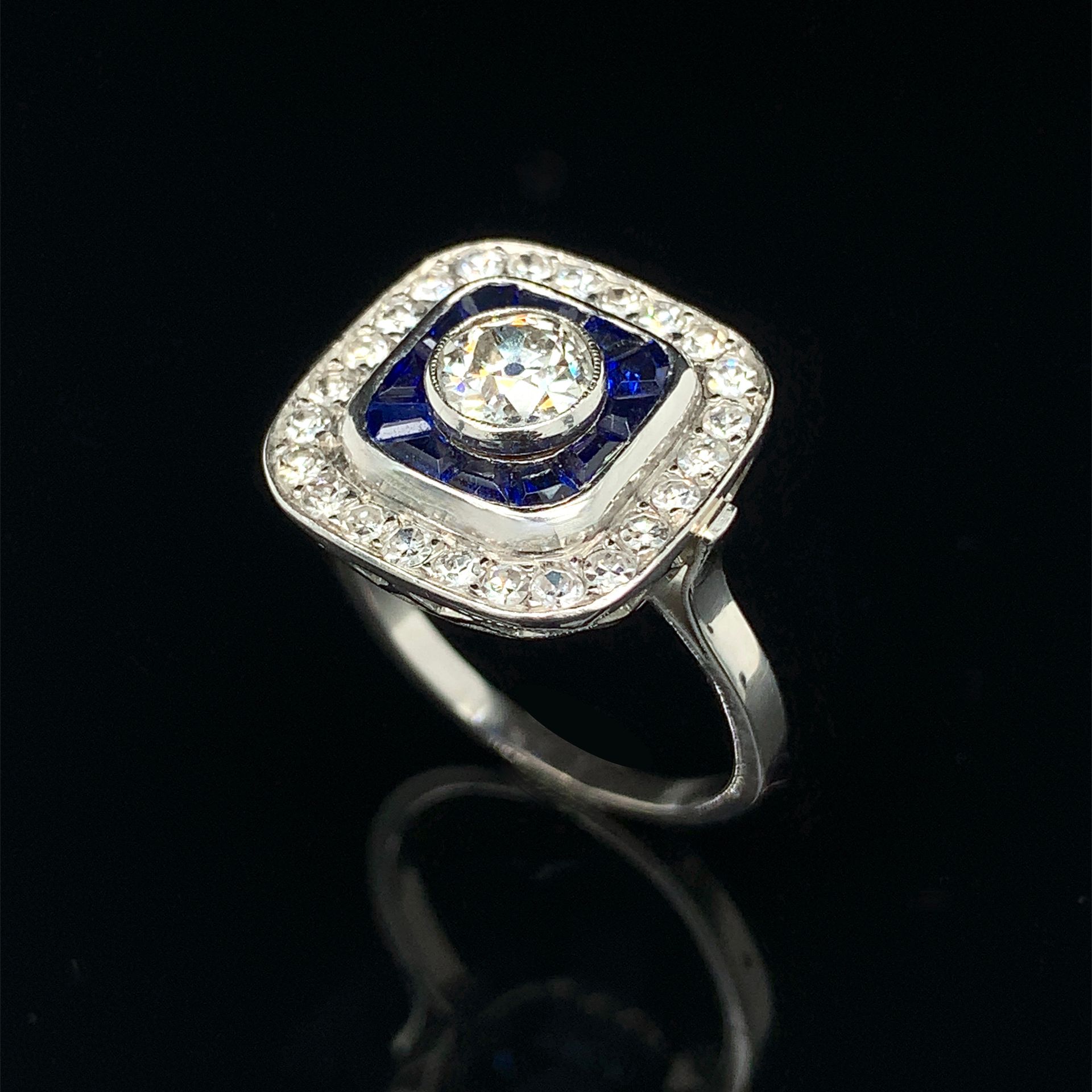 Null 铂金（950‰）和白金（750‰）"枕形 "戒指，以老式切割钻石为中心，周围是校准蓝宝石和8/8切割钻石。
法国作品。
手指：57 - 长度：1.2 &hellip;