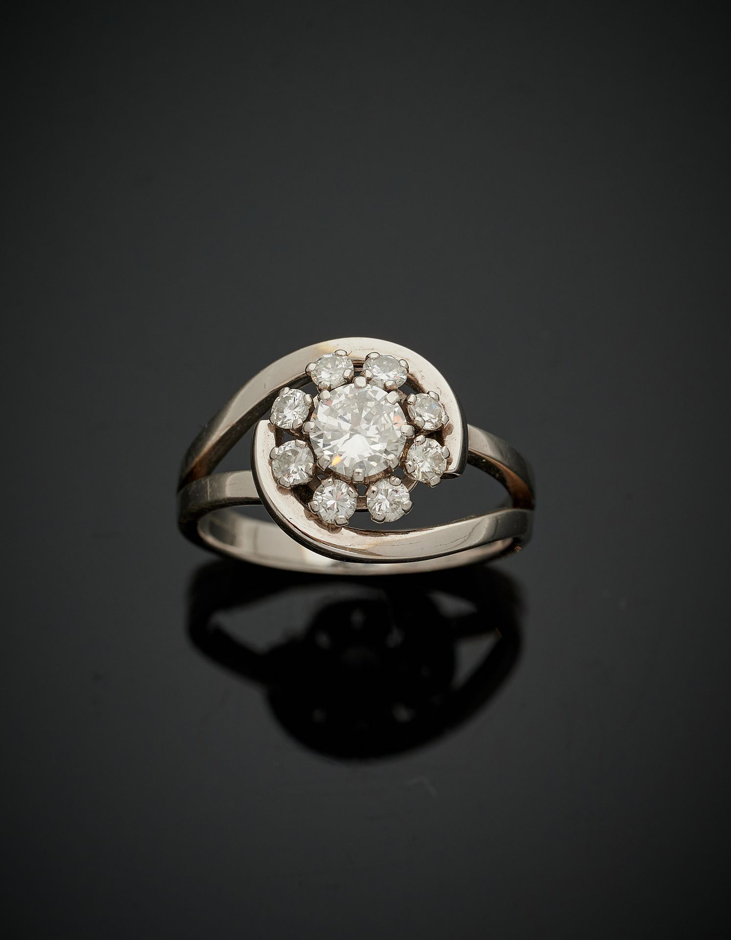 Null 白金（750‰）风格的镂空涡旋 "玛格丽特 "戒指，镶有九颗圆钻，其中一颗在中央较大。
手指 : 57 - 毛重 : 6,6 g