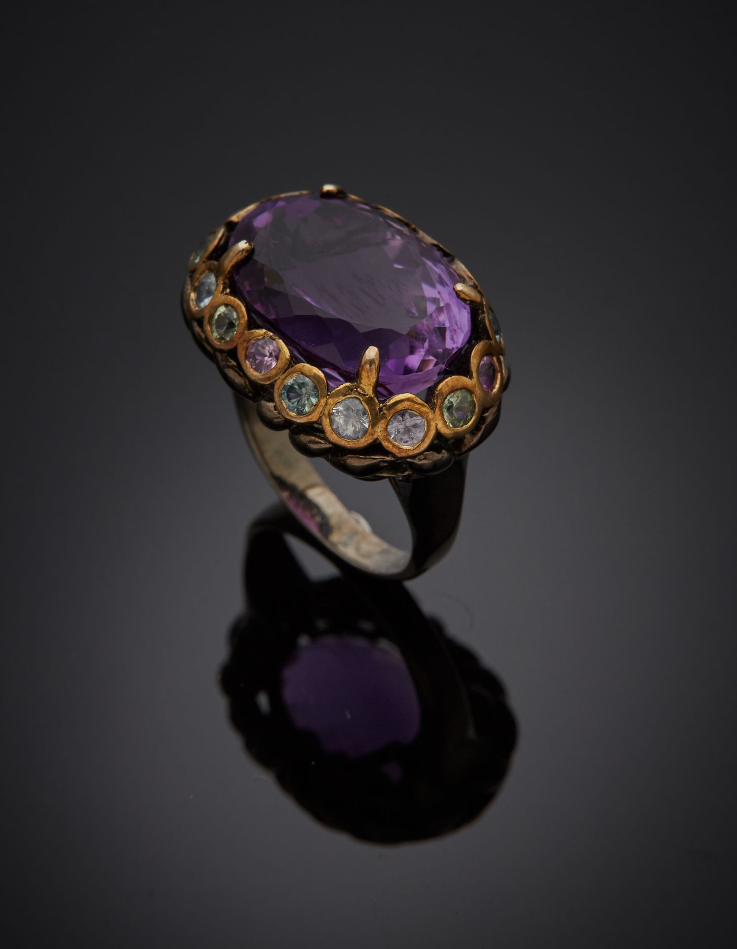 Null 发黑的银和镀金(925‰)镂空戒指，镶嵌着一颗重约10克拉的椭圆形紫水晶，周围是粉色、绿色和蓝色黄宝石。
手指 : 56-57 - 毛重 : 9,6 &hellip;