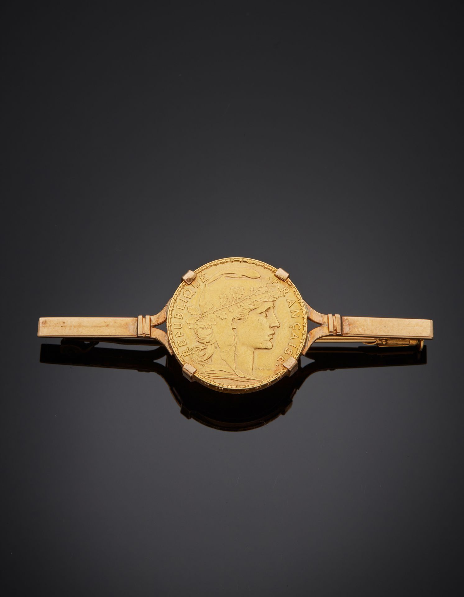 Null 一枚黄金（750‰）"发夹 "胸针，中心是一枚20法国法郎硬币，玛丽安（1911年）的黄金（900‰）。
长度 : 6 cm - 重量 : 10,6 &hellip;