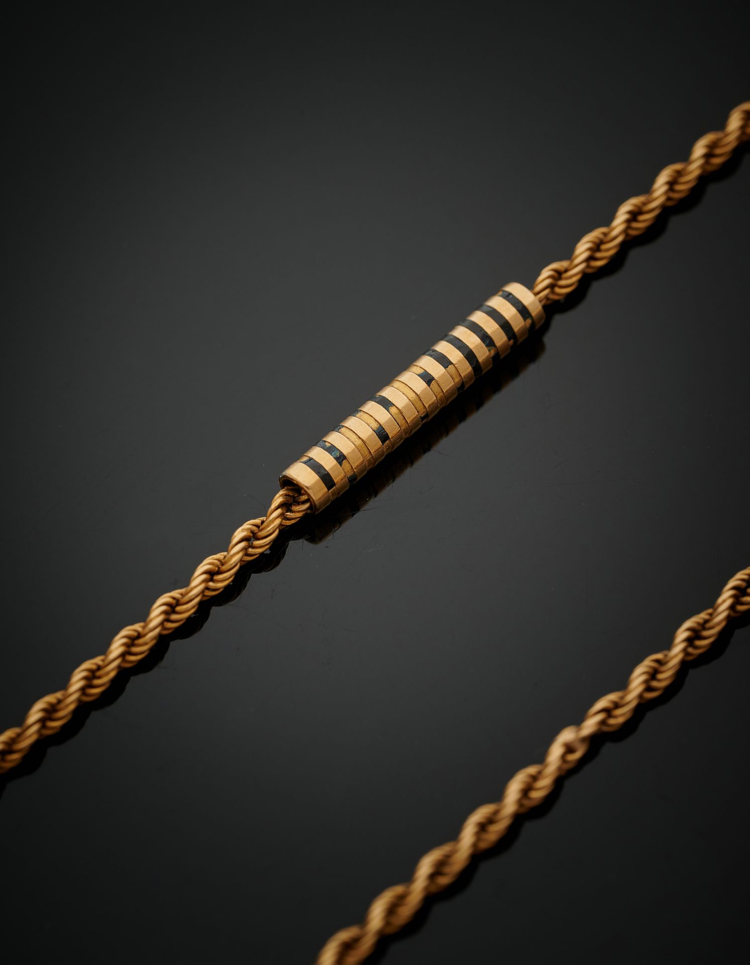 Null 一条黄金（750‰）扭曲的链子，交替着十二个凹槽的管状图案，以前是用黑色珐琅装饰的（很多都没有珐琅）。
法国作品，约1900年。
长 : 160 cm&hellip;