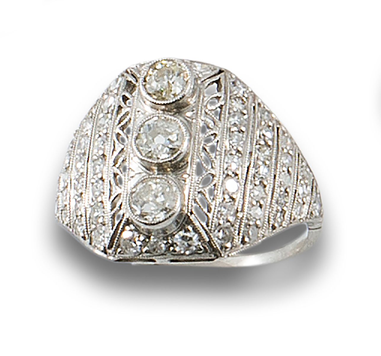 Platinum bombé ring. 由三颗中央的老式切割钻石组成，镶嵌在镂空的底座上，并镶嵌着简单切割的钻石。