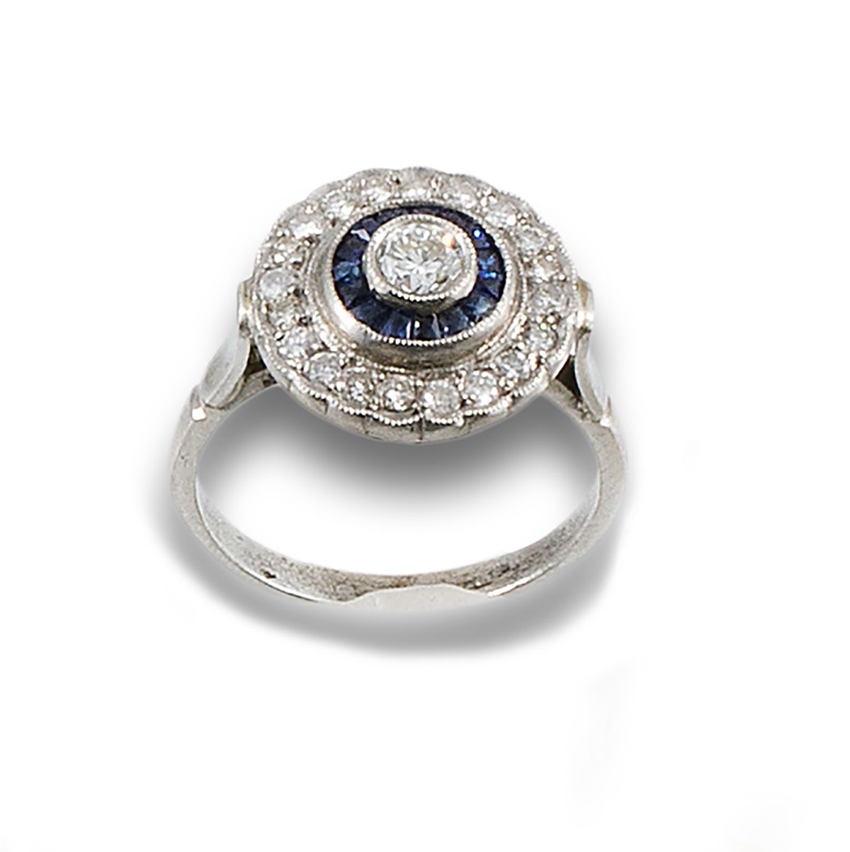 Platinum bird's eye ring. 由中央的钻石组成，明亮式切割，估计为0.20克拉，边上是校准的蓝宝石和钻石边，明亮式切割。