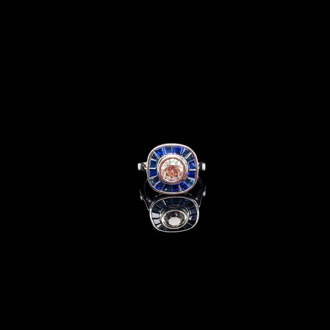 BAGUE en or gris, diamant et saphirs 一枚白金（750‰）戒指，在一圈校准的蓝宝石中镶嵌了一颗封闭式的明亮式切割钻石。
钻石&hellip;