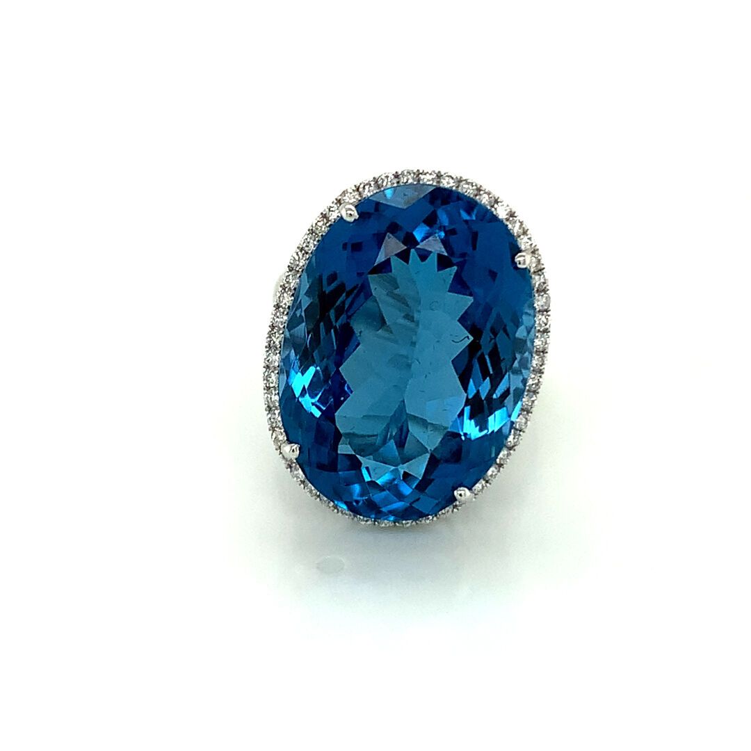 BAGUE en or gris, topaze et diamants 一枚白金（750‰）镂空戒指，镶嵌着一颗大的椭圆形琢面蓝色托帕石，边上是一排小型明亮式&hellip;
