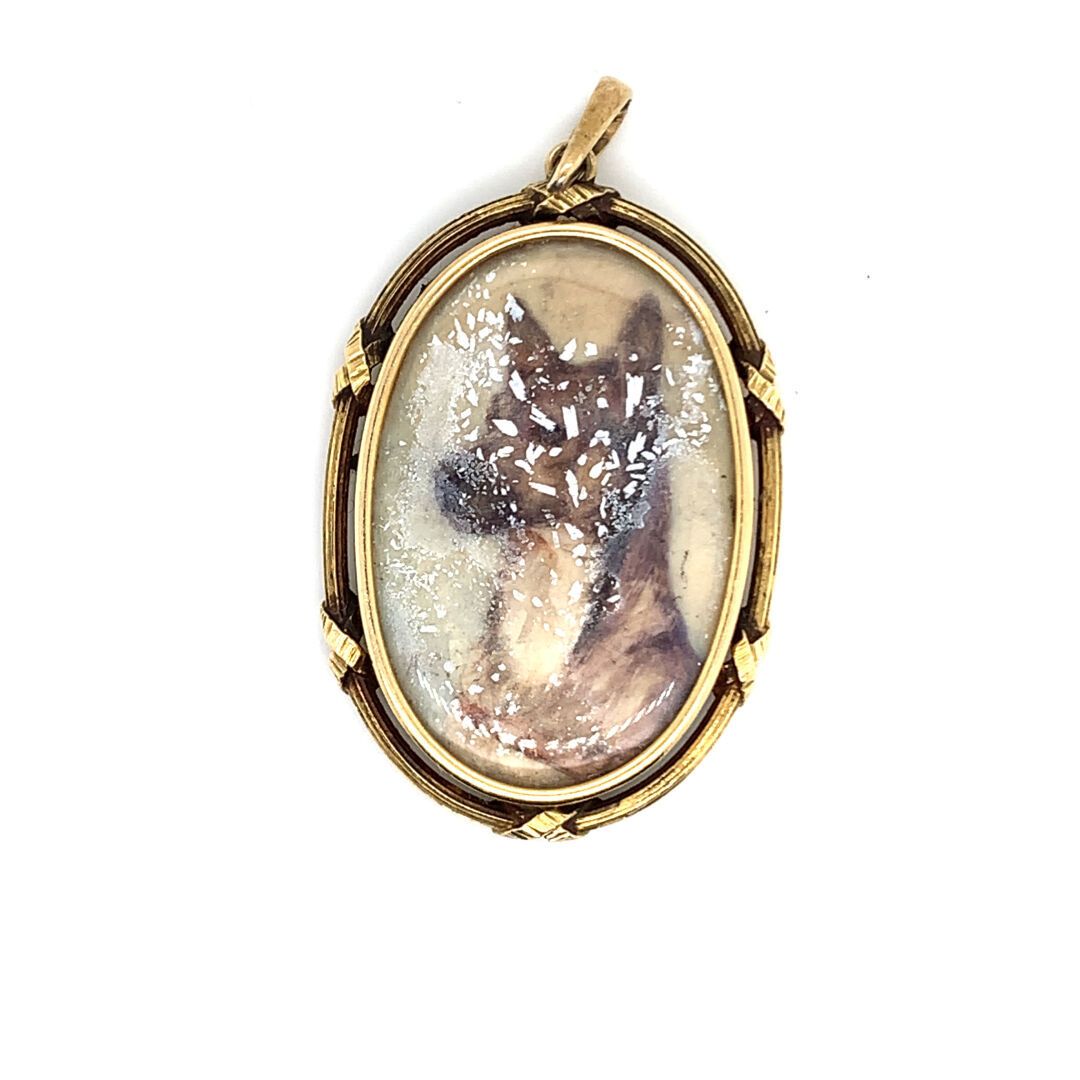 PENDENTIF « souvenir » en or 金质（750‰）"纪念品 "吊坠，装饰有一只狗的肖像，背面有带状和雕刻的装饰。
毛重：11.20克。高&hellip;