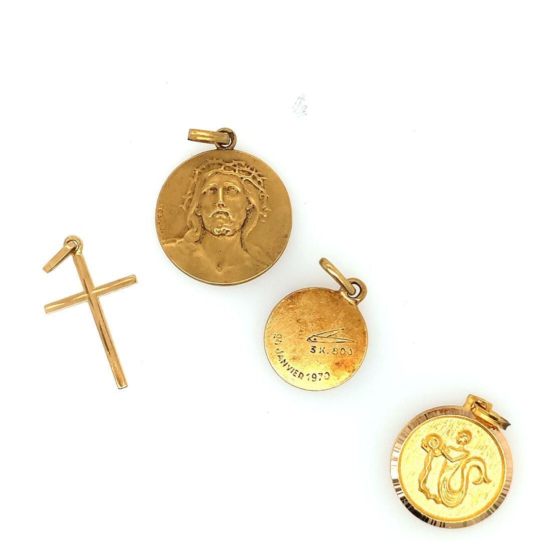 TROIS PENDENTIFS en or 三枚金质吊坠（750‰），包括两枚勋章和一个十字架。
重量：4.75克。
附有一个镀金的金属奖章。