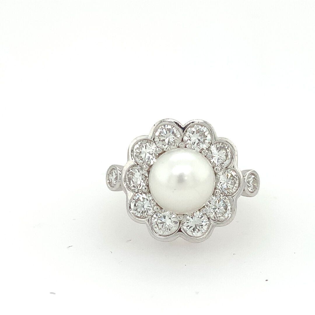 BAGUE en or gris, perle et diamants 一枚白金（750‰）花戒，以珍珠为中心，周围是封闭式镶嵌的小型明亮式切割钻石。
毛重：6&hellip;