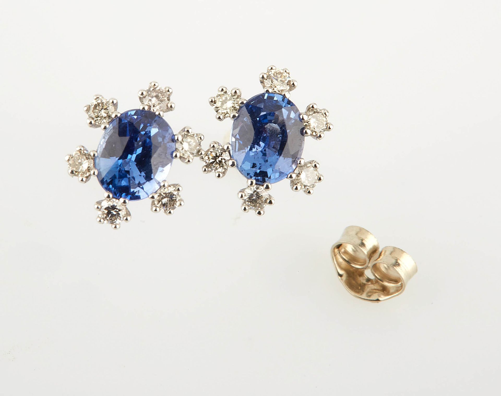 Null 一对白金耳环，镶有两颗椭圆形蓝宝石（约1.10克拉）和12颗圆形现代钻石（约0.20克拉）。