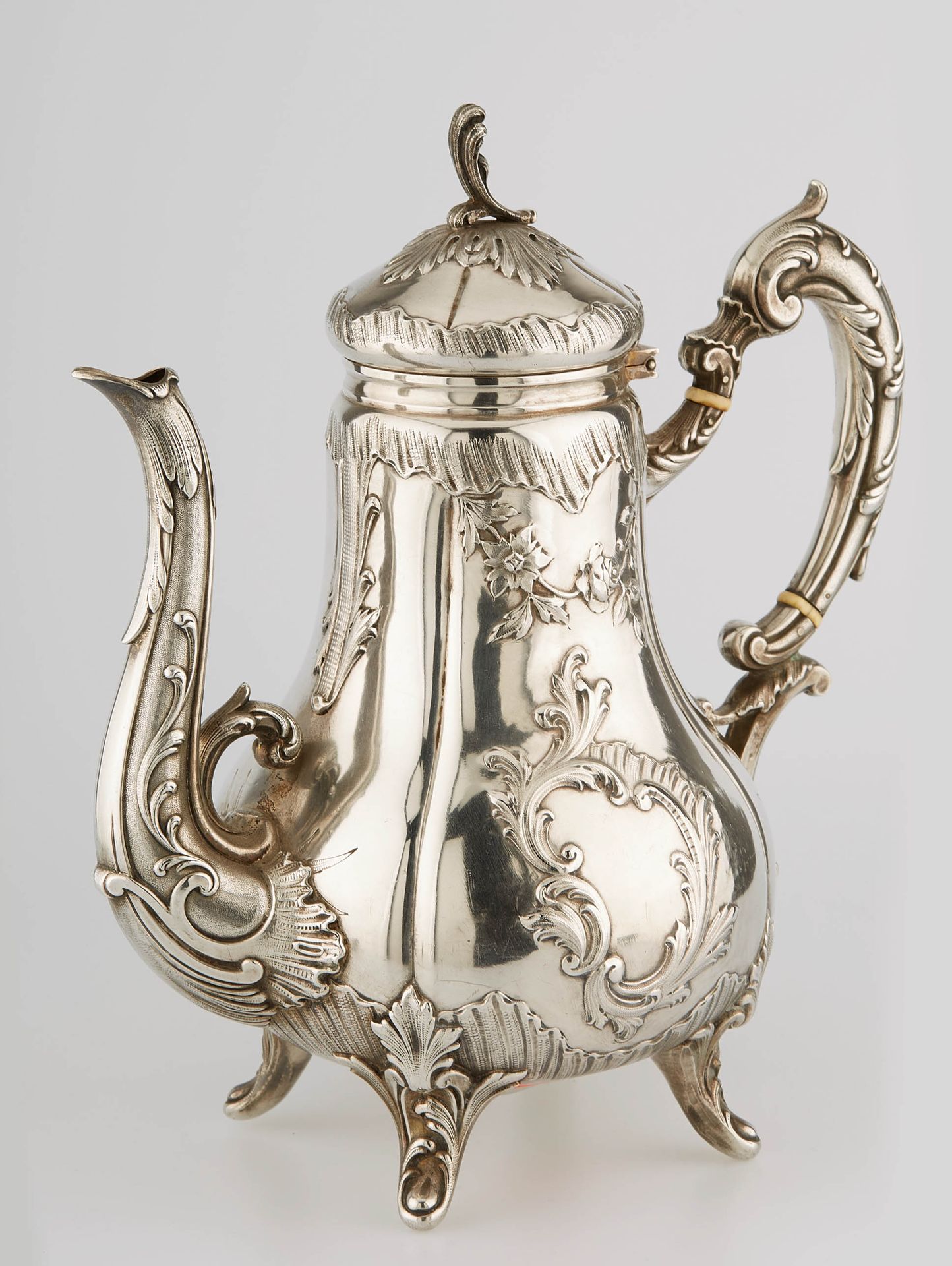 Null A baluster-shaped silver coffee pot resting on four moulded feet with folia&hellip;
