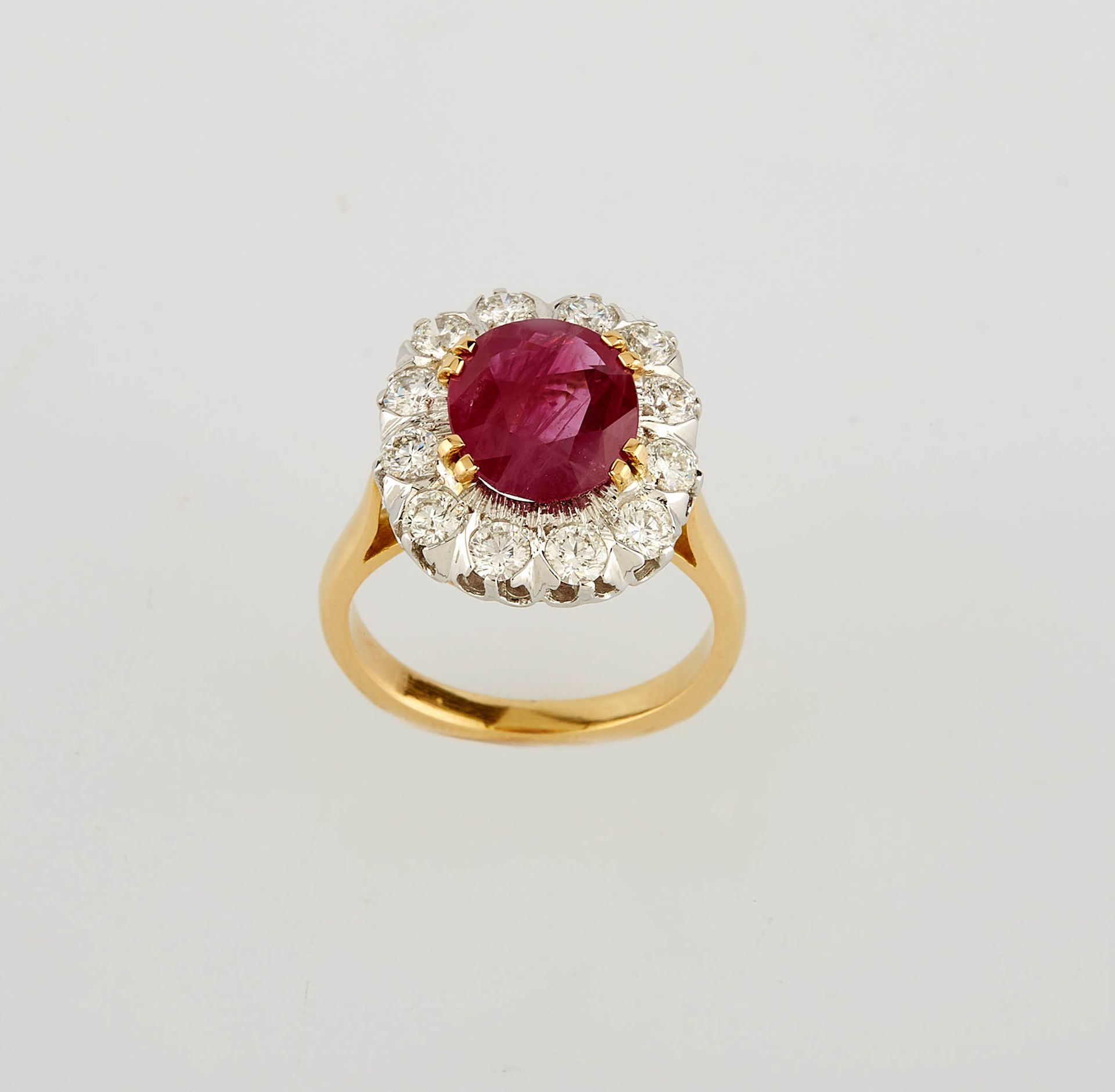 Null 黄白金 "Marguerite "戒指，中央镶嵌一颗3.21克拉的椭圆形缅甸红宝石，配以12颗现代切割白钻（约1克拉）。 手指尺寸：54。重量：7.8&hellip;