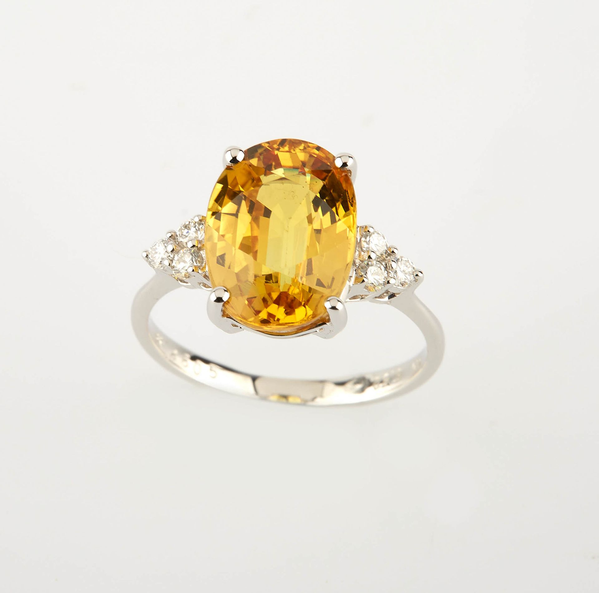 Null 白金戒指，镶嵌着一颗椭圆形切割的黄色蓝宝石，重约5.60克拉，还有六颗圆钻，重约0.20克拉。重量：3.20克。
