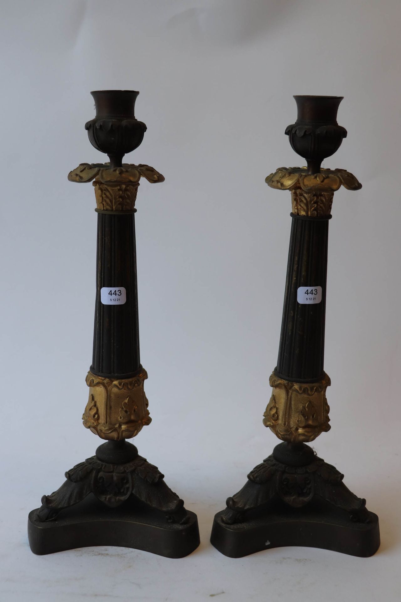 Null A pair of candlesticks in brown and gilt patina, the shaft of which is topp&hellip;