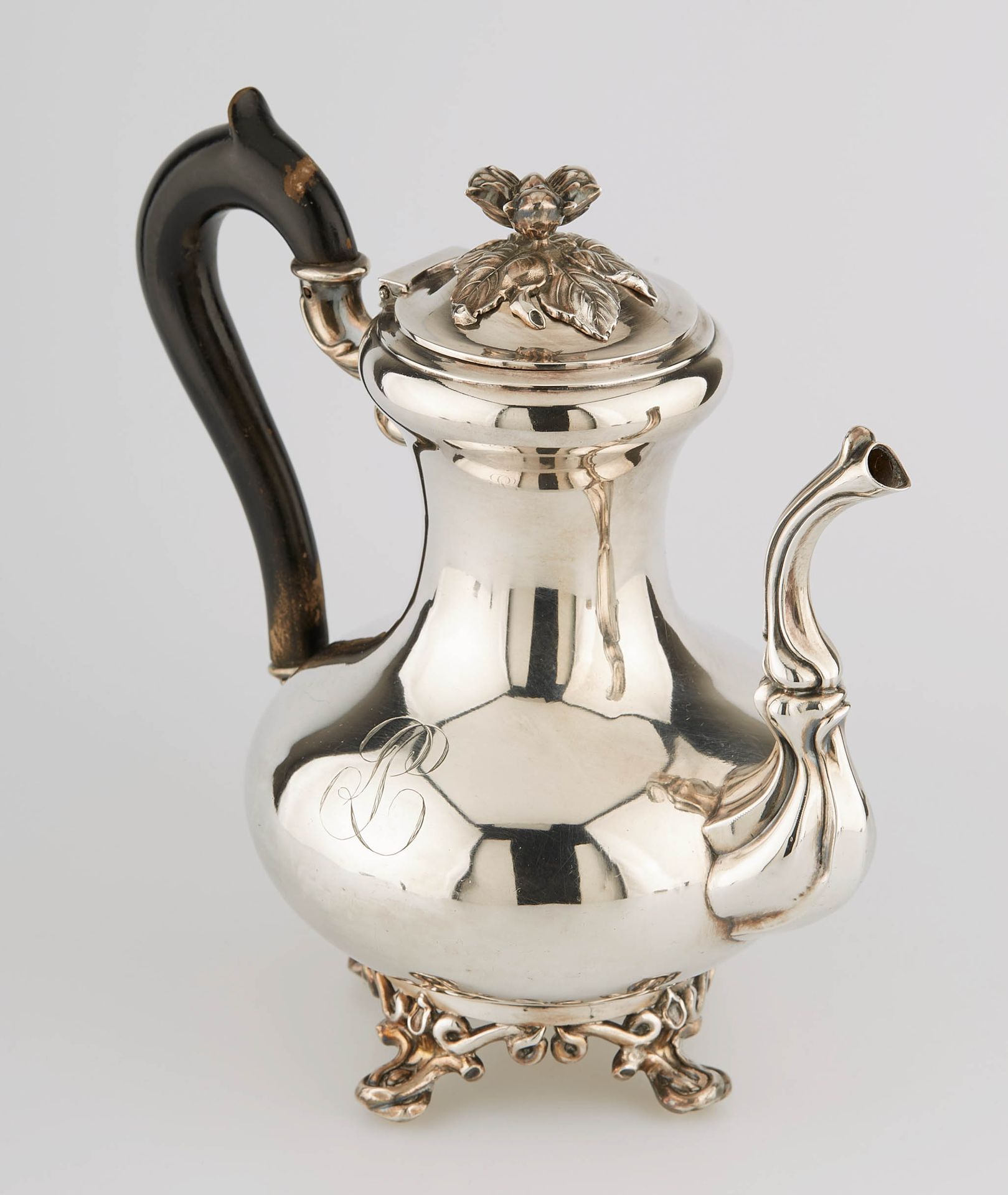 Null 一个小的银色柱状咖啡壶，放在四个模制的脚上，有一个铰链的盖子，上面有一个榛子装饰的把手。熏黑的木质手柄。标记为Minerve，19世纪。M.O.: D&hellip;
