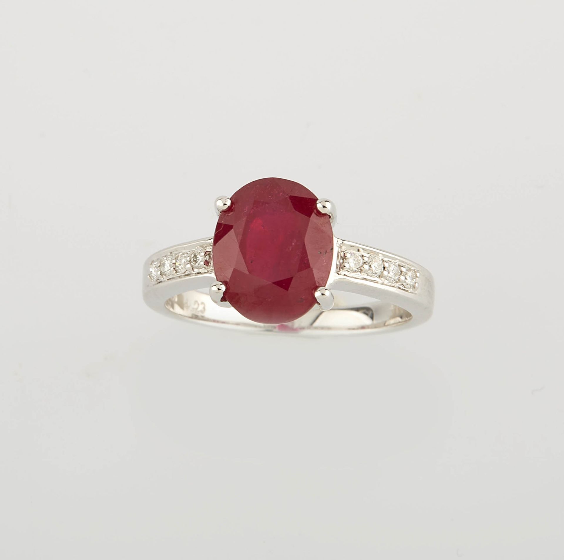 Null 白金戒指上镶嵌着一颗经过处理的椭圆红宝石，重约4.20克拉，以及八颗现代圆钻，重约0.10克拉。