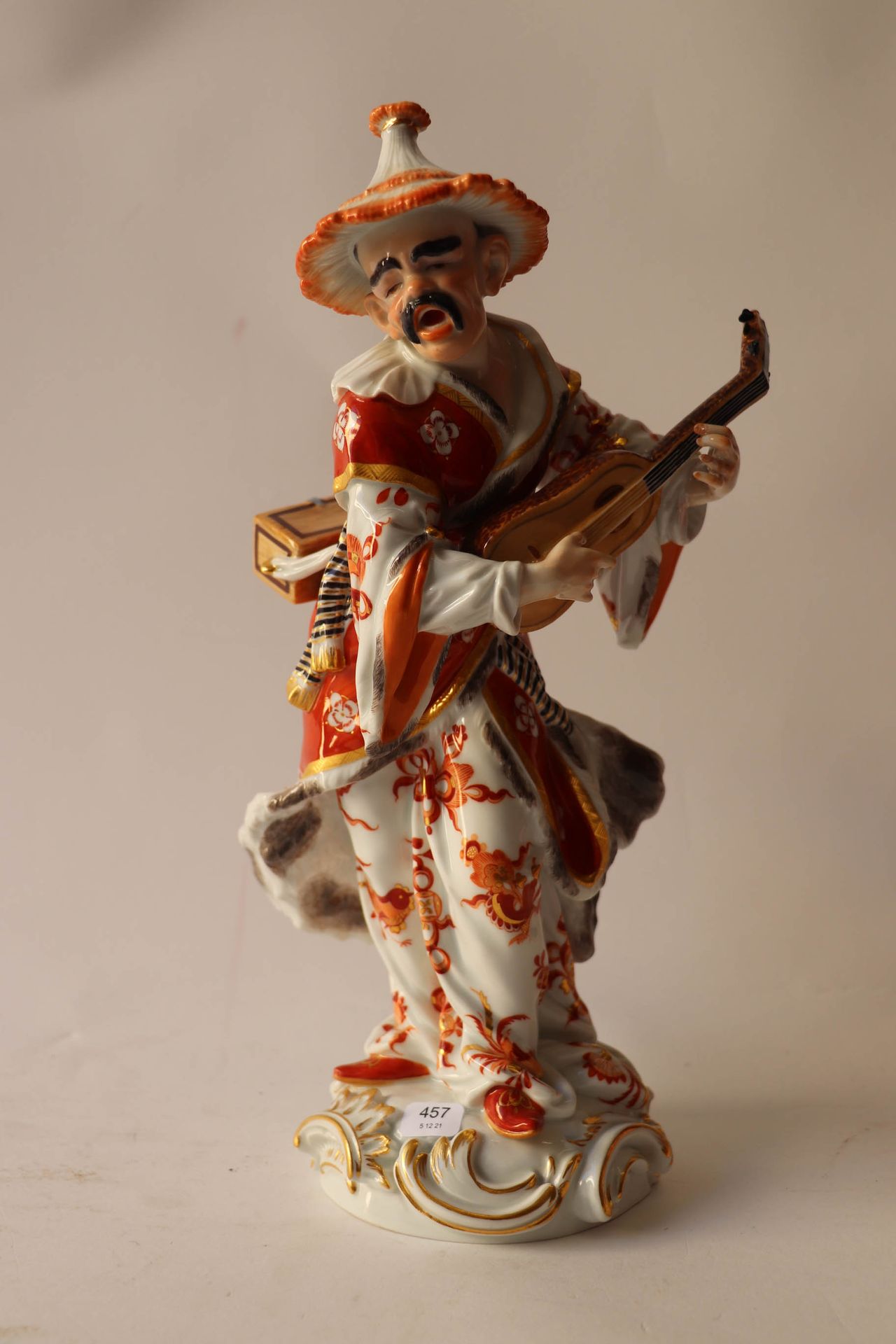 Null 白色、红色和金色的瓷器主体上装饰着一个弹奏弦乐器的亚洲老歌手。高度：31厘米。高度：31厘米。