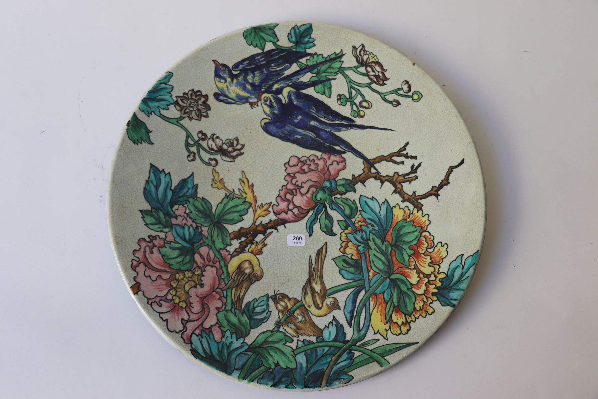 Null 大圆陶盘，米色背景上有鸟、花和树叶的多色装饰。直径：38厘米。有两个小的珐琅质碎片。