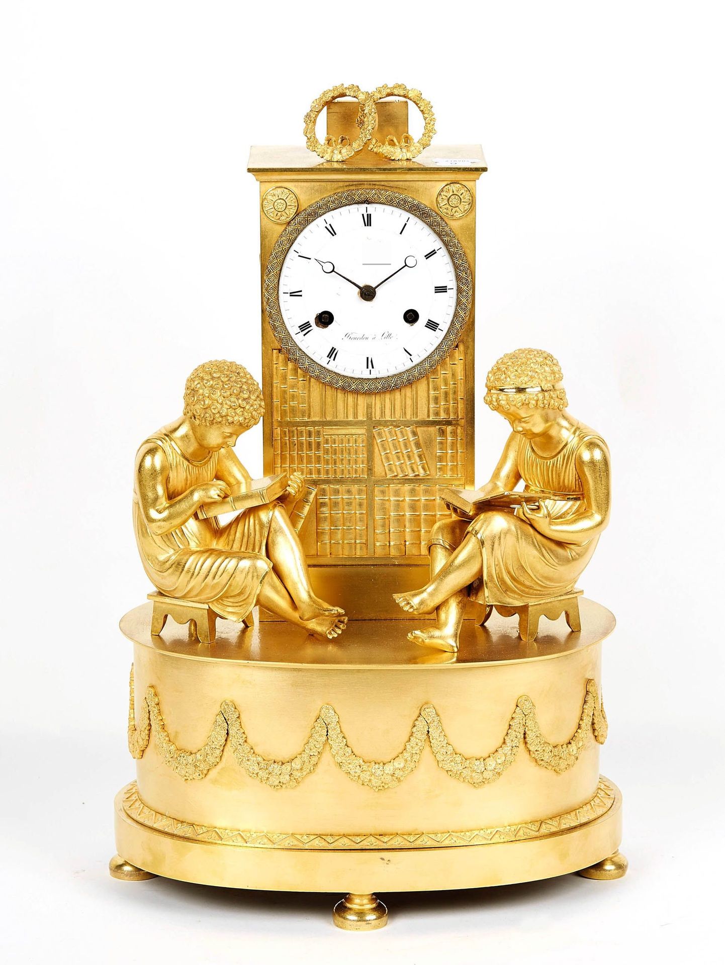 Null 美丽的鎏金铜钟，白色珐琅表盘（小缺口），编号为 "Beurdon à Lille"，设置在一个模拟图书馆的终端，上面有两个花环，椭圆形的底座上装饰着花&hellip;