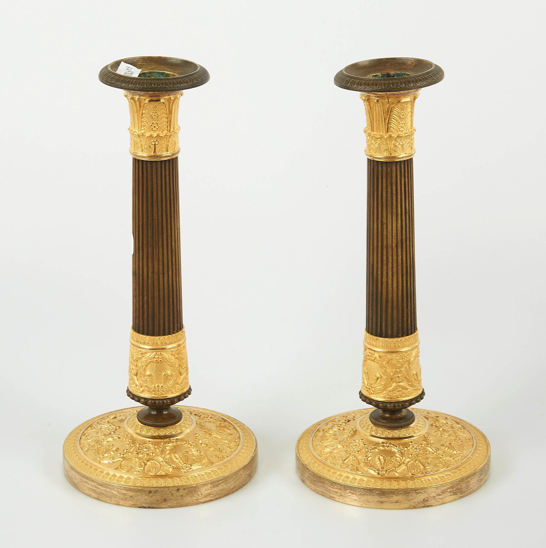 Null A pair of ormolu torches with a brown patina, the round base chiselled with&hellip;