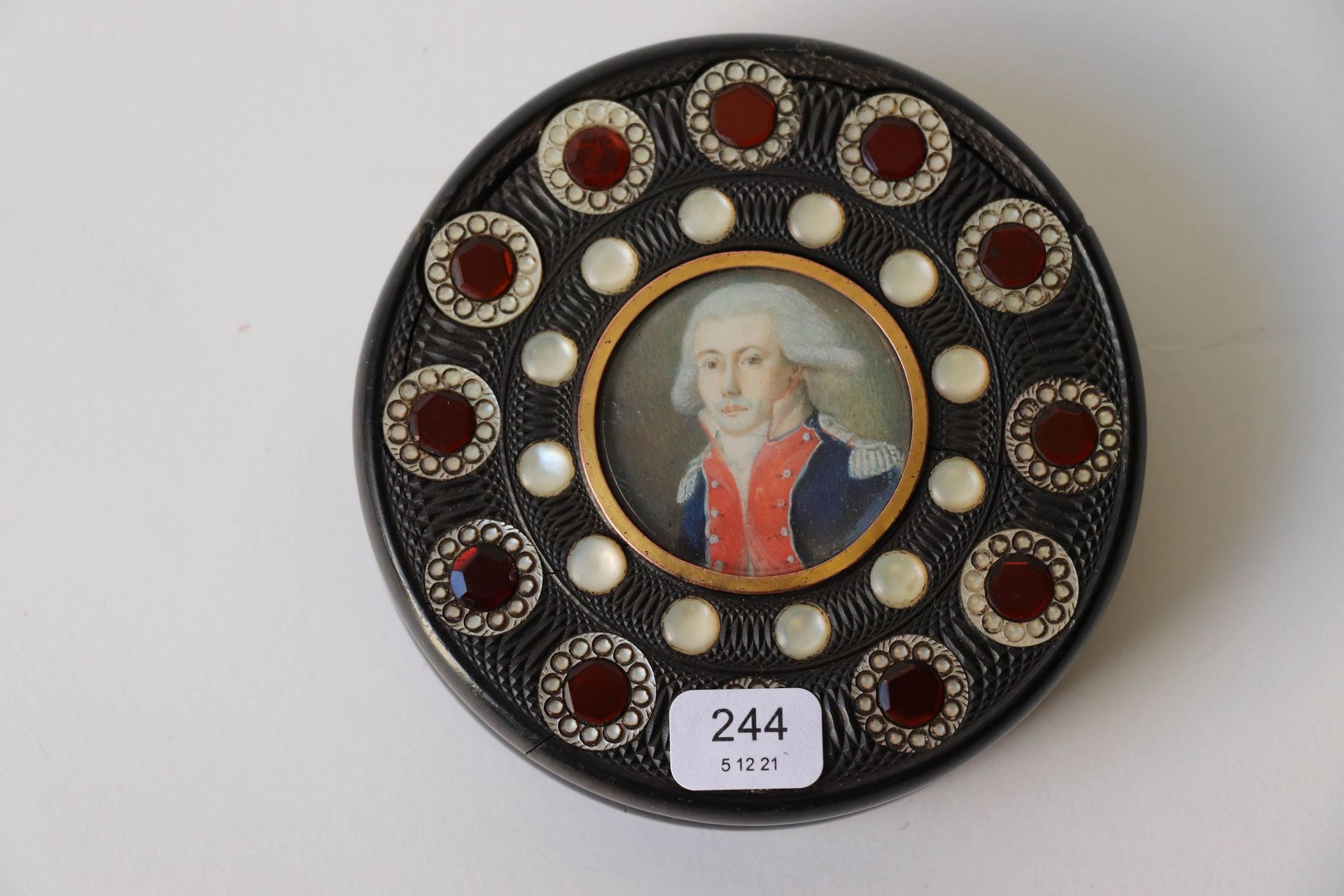 Null 一个棕色着色的角质盒，上面装饰着代表 "La Fayette "的多色彩绘圆形缩影，并有珍珠母半珠和橙色的刻面玻璃。直径：9.5厘米。事故。