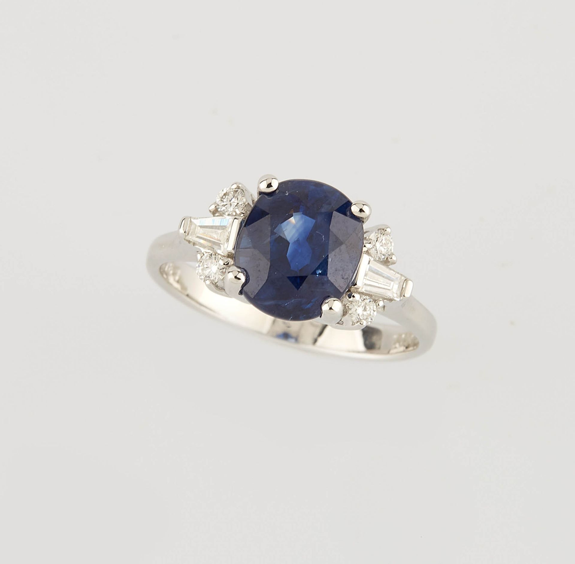 Null 白金戒指，中央镶嵌一颗约3.10克拉的椭圆形蓝宝石，并有四颗约0.10克拉的圆钻和两颗约0.15克拉的方钻。 手指大小：52.5。重量：3.60克。