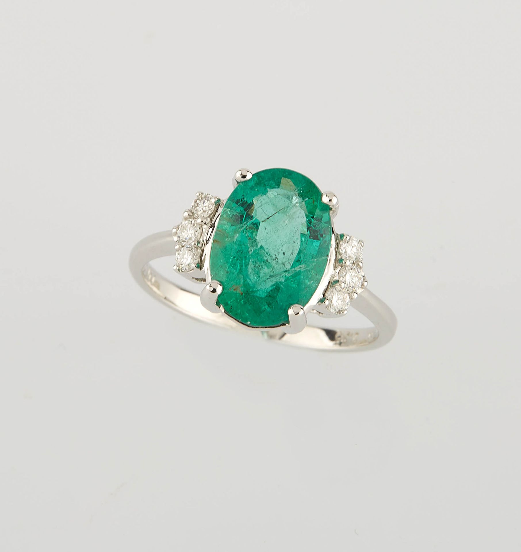 Null 椭圆形白金戒指，中间镶嵌了一颗约2.35克拉的椭圆形祖母绿和六颗约0.20克拉的圆钻。 手指尺寸：53.5。重量：3.05克。