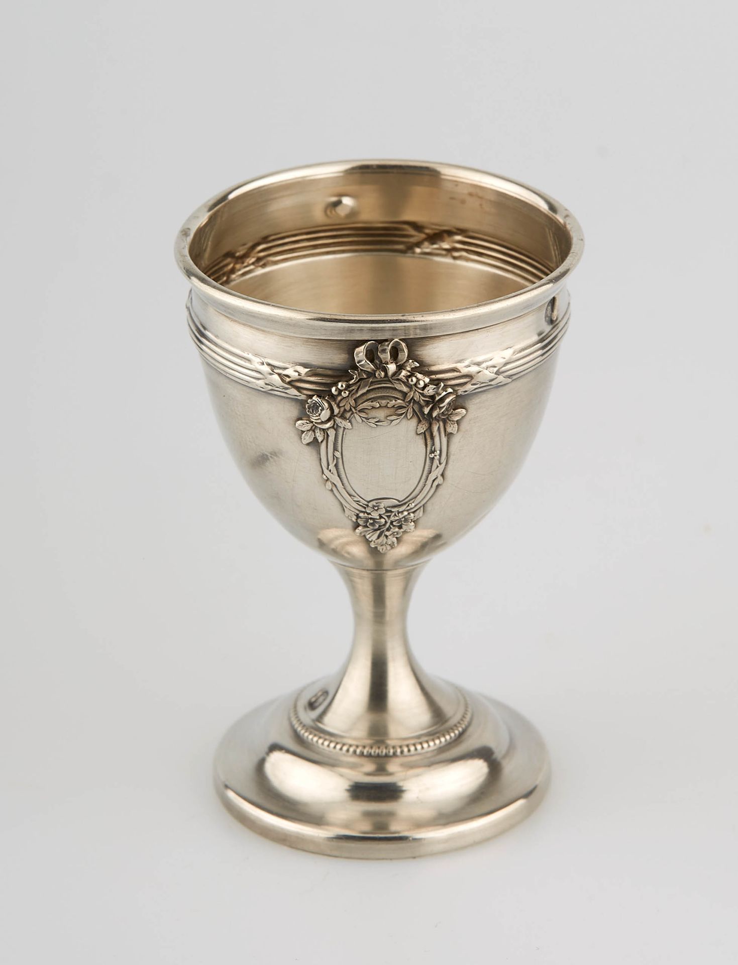 Null 银质蛋杯放在一个圆形的珍珠基座上，其主体绣有网和丝带，并装饰有处女的保留。标记的Minerve。高度：7厘米。高度：7厘米。重量：21克。