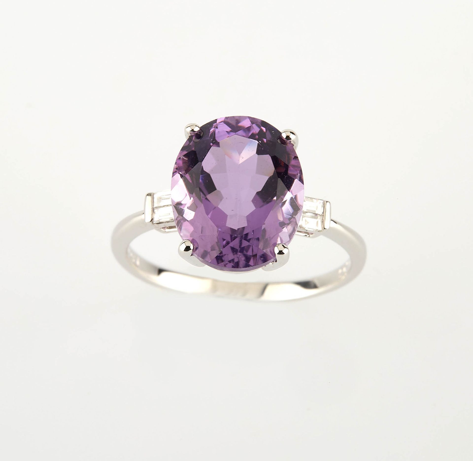 Null 白金戒指，镶嵌着一颗重约4.60克拉的椭圆形紫水晶和四颗重约0.10克拉的长方形切割钻石。 手指大小：53.5。重量：3.15克。