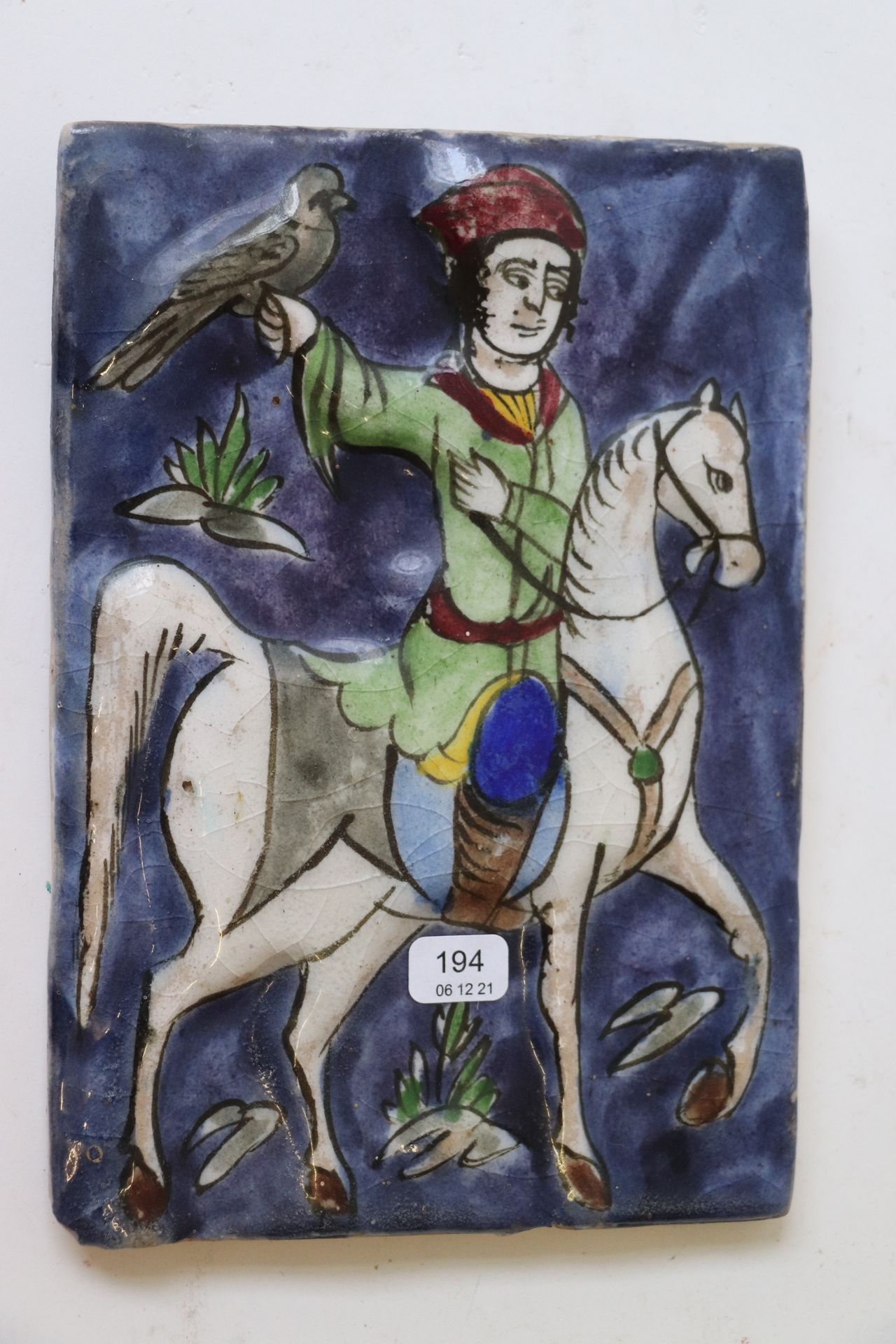 Null 伊朗。陶器瓦片，上面有多色装饰，一个骑手抱着一只鸟。20.5 x 19 厘米。