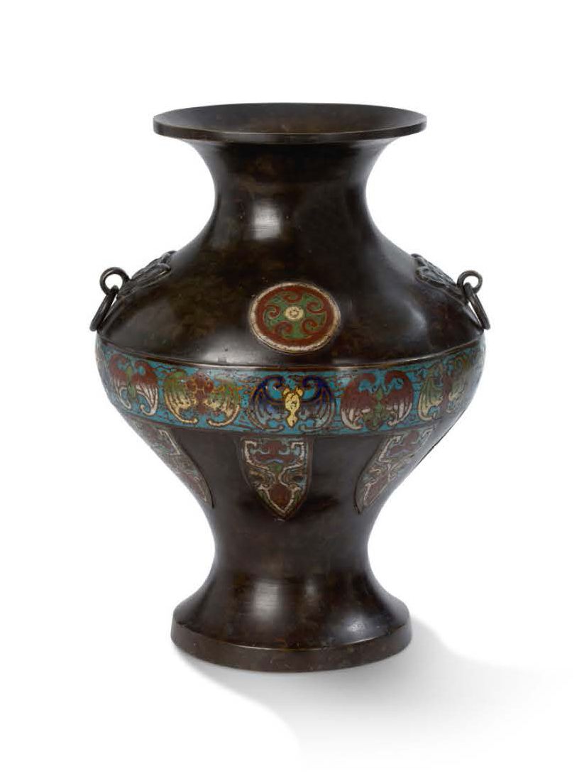 JAPON vers 1900 膨胀的青铜柱形花瓶，带有棕色的铜锈和champlevé珐琅，装饰有蝙蝠、风格化的蝉和花饰，两个把手有狼头，拿着移动环。
，高33&hellip;
