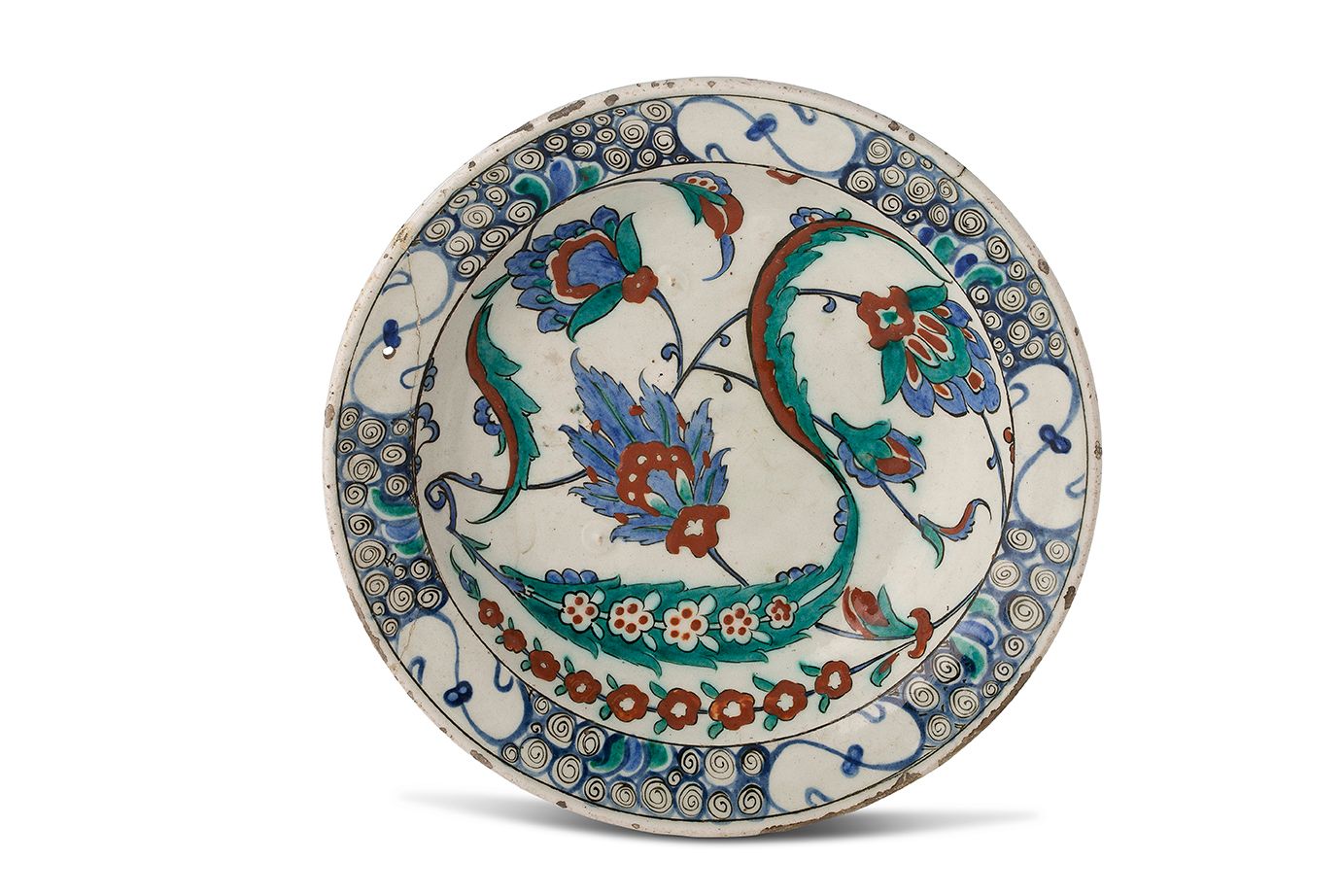 [IZNIK] 
一个硅质陶瓷 "tabak "盘，在白底上用多色装饰着一个大花边的 "saz "棕榈，上面点缀着花朵，周围是康乃馨和金银花。
边缘装饰着 "波&hellip;