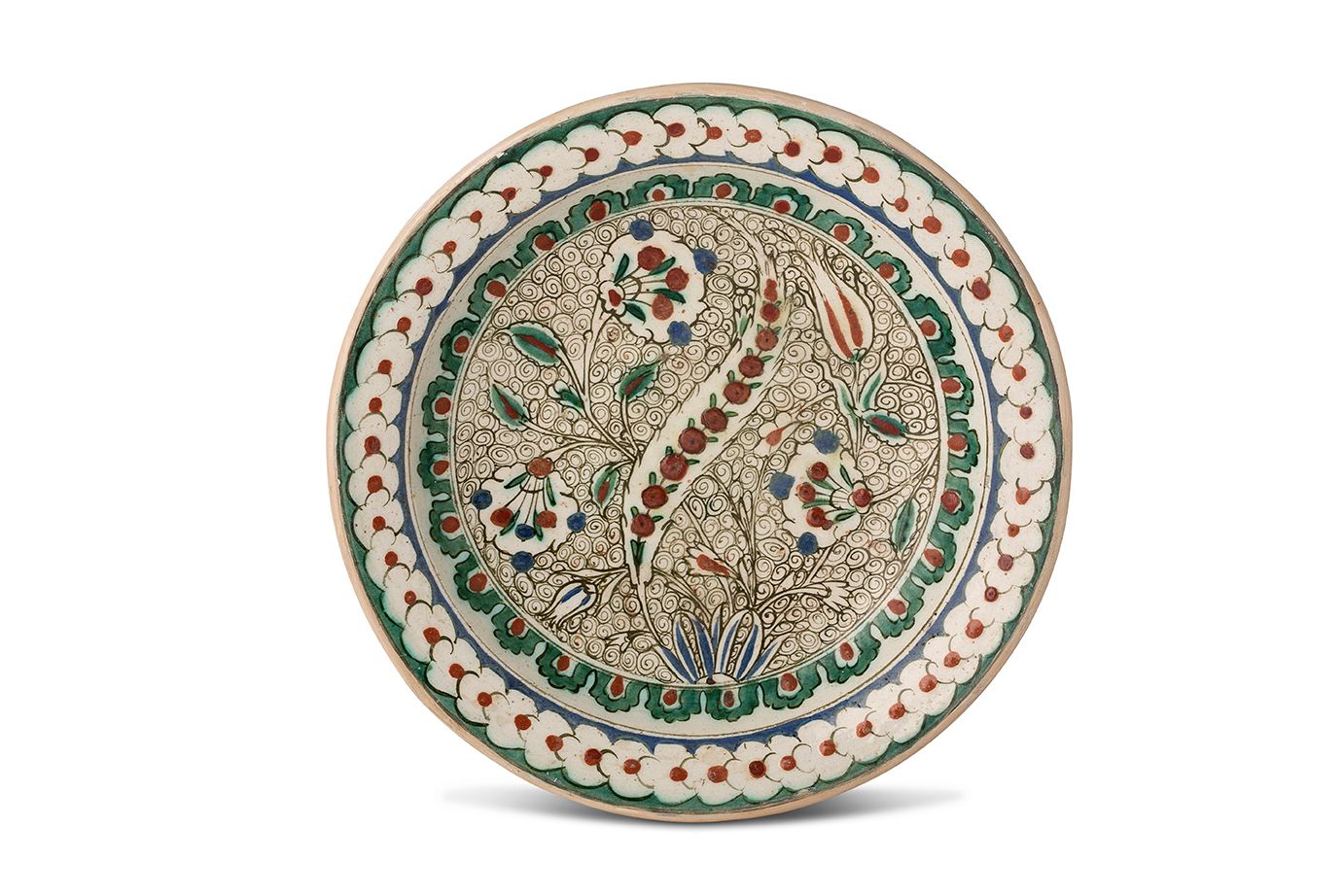 [IZNIK] 
一个硅质陶瓷 "tabak "盘，在白底上用多色和红色的滑石装饰着一个锯齿状的 "saz "手掌，周围是康乃馨和郁金香，有丰富的风格化的波浪框&hellip;